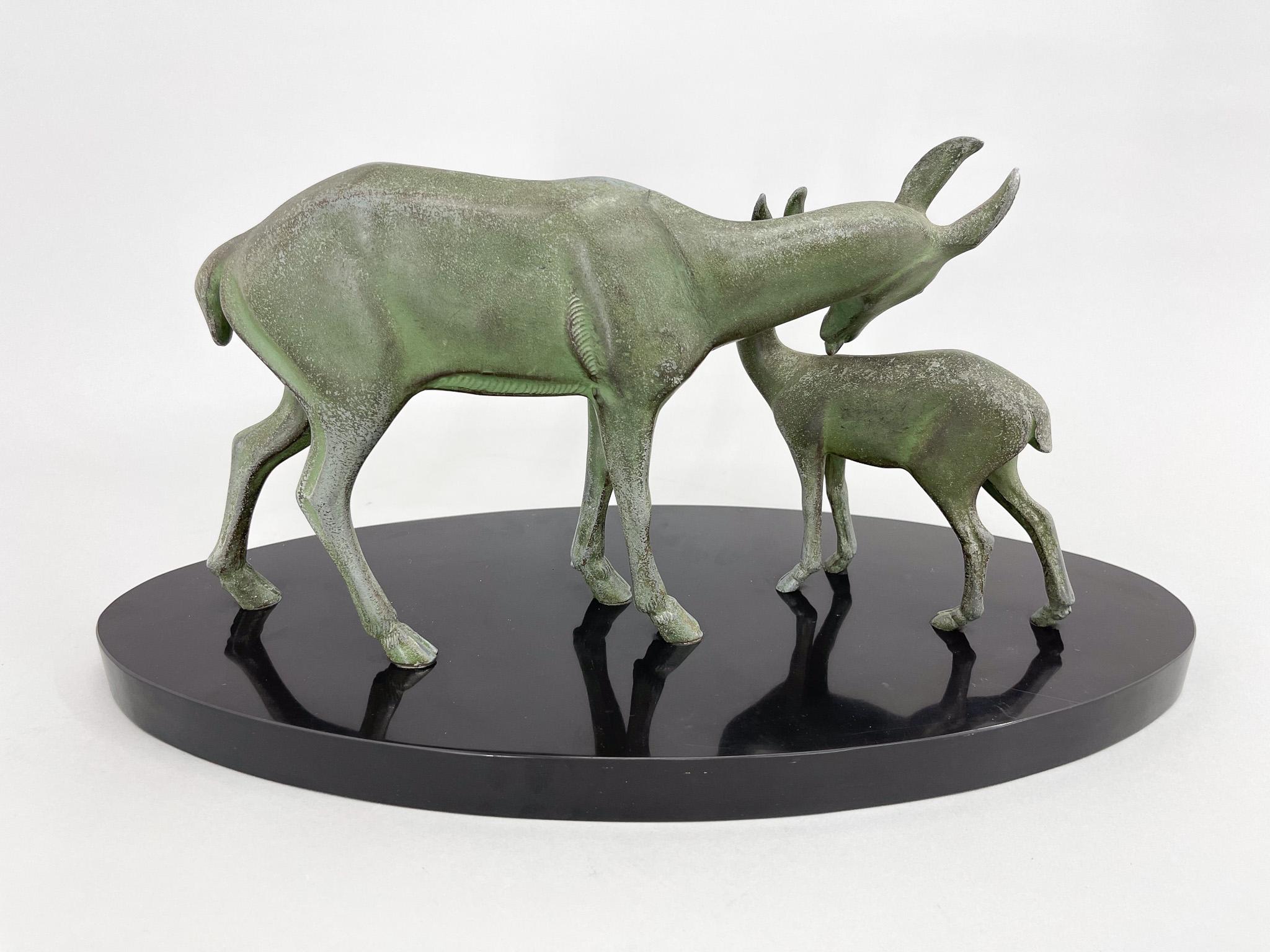 Art deco sculpture  of a roe deer with fawn on black base.
