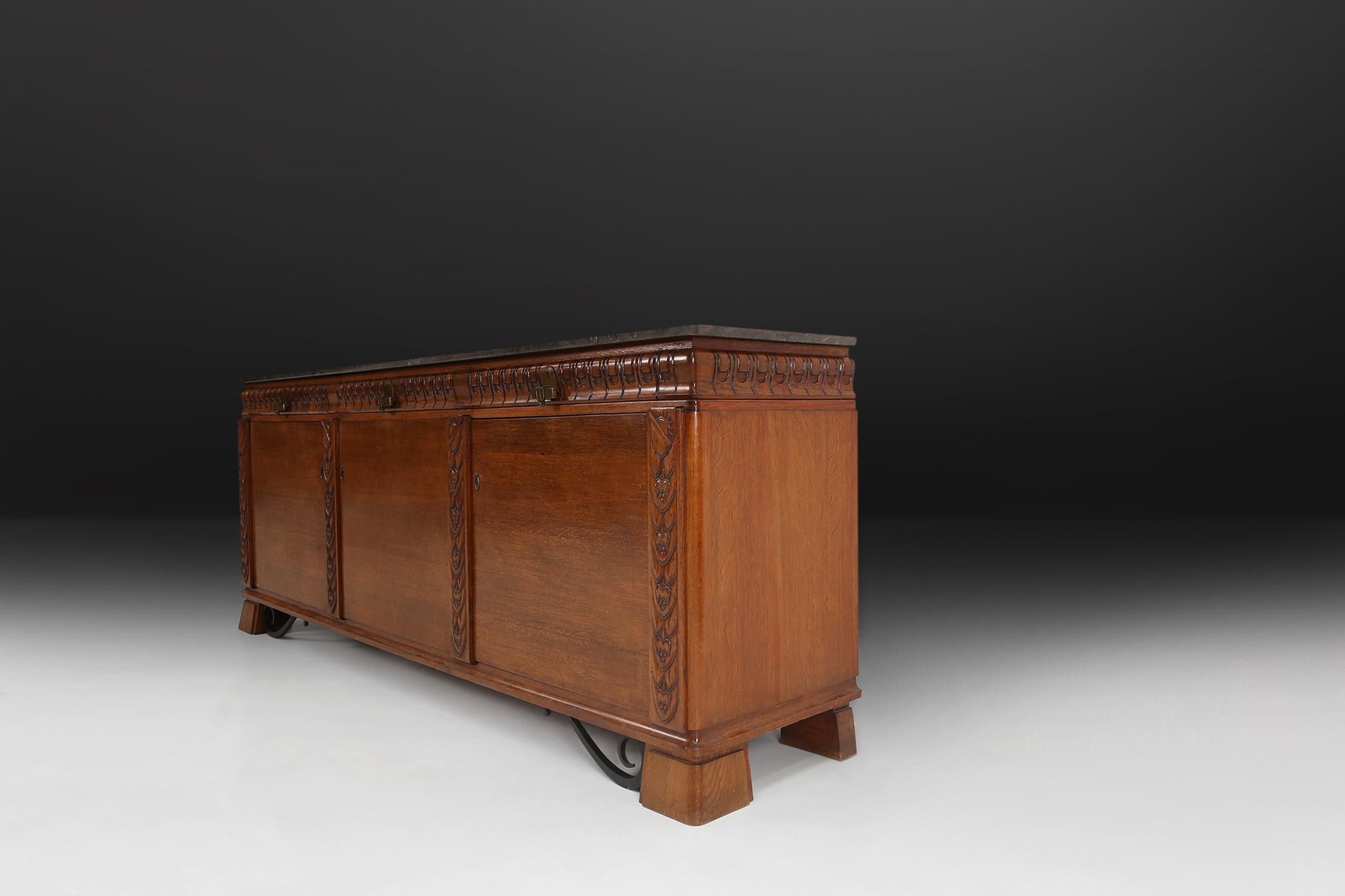 Large Art Deco sideboard made in the 1940s with some great sculptural details in the wood and metal details on the base. With a beautiful grey marble top.