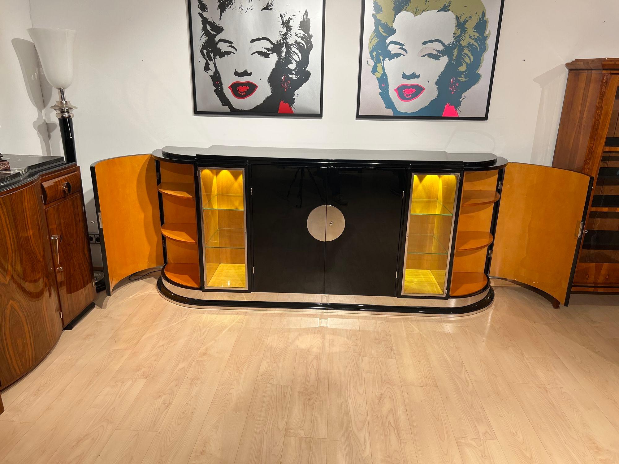 Large Art Deco sideboard in black lacquer and maple with metal fittings from France around 1930.
Very elegant, balanced and typical Art Deco design. Black piano lacquer, high gloss polished. Body rounded at the sides with curved doors and stepped