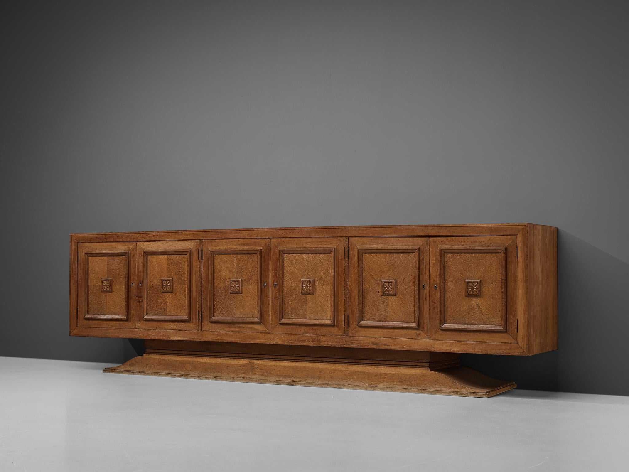 Sideboard, oak, felt, France, 1940s

Grand Art Deco sideboard with five graphical doors. This expressive credenza features striking woodwork. An overall patina contributes to the authentic look of the sideboard. In this sideboard, sturdy elements
