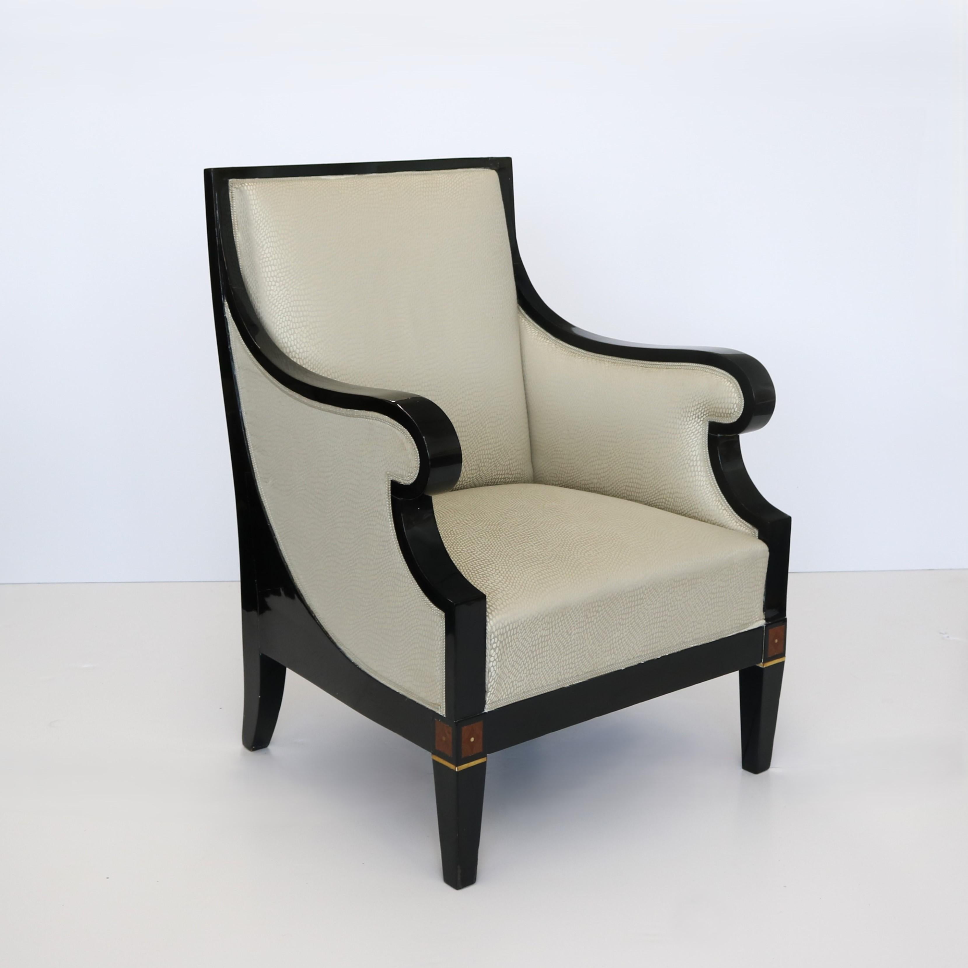 Grande bergère simple de style Art déco. Cadre en laque noire avec incrustations en bois fruitier.  Les accoudoirs présentent un motif de volutes saisissant, les retours encadrant les panneaux d'accoudoir rembourrés.  Restauré et nouvellement