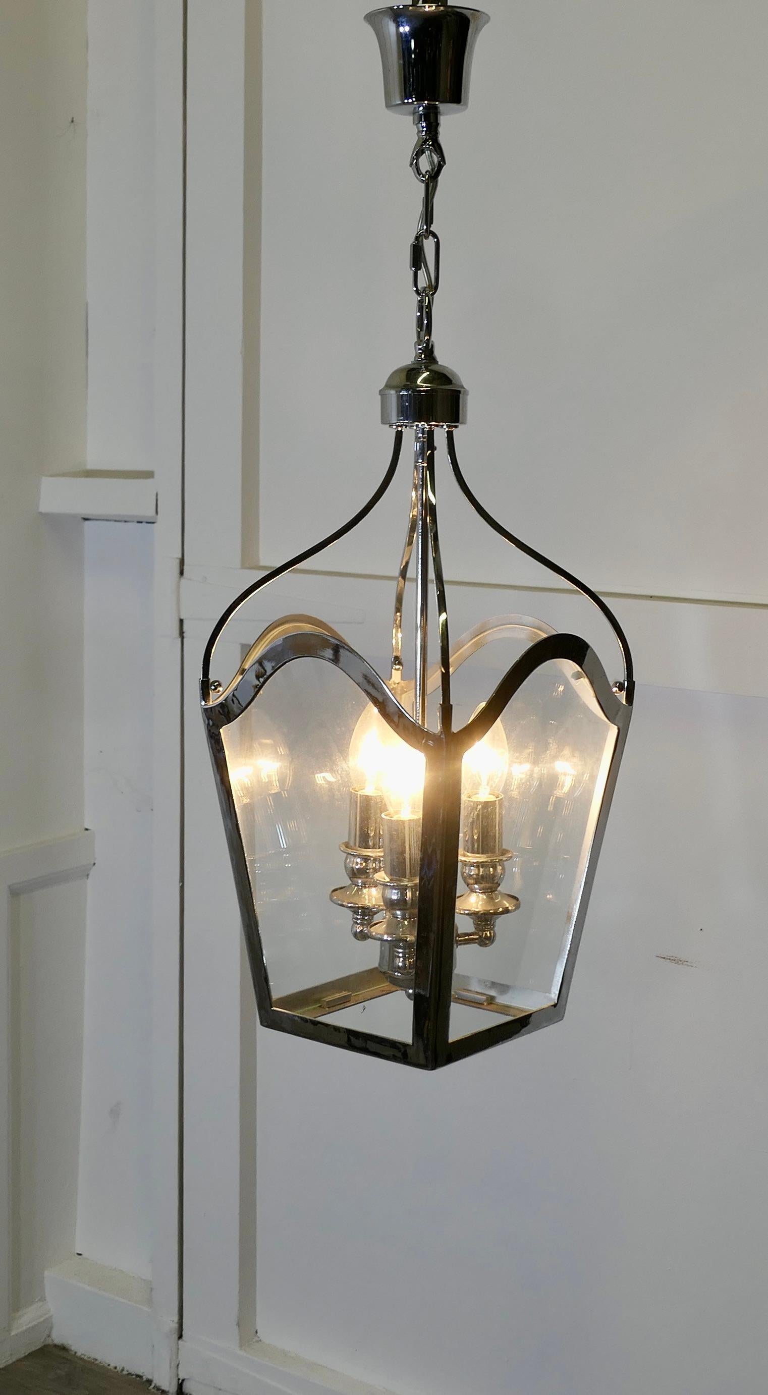 Large Art deco Style Chrome and Glass Lantern, Hall Light

This lovely large light is has 4 flat shaped glass panels 
The lantern has 3 lamps to the interior and gives a sensational bright light when lit
The lantern frame is chrome and it hangs on a