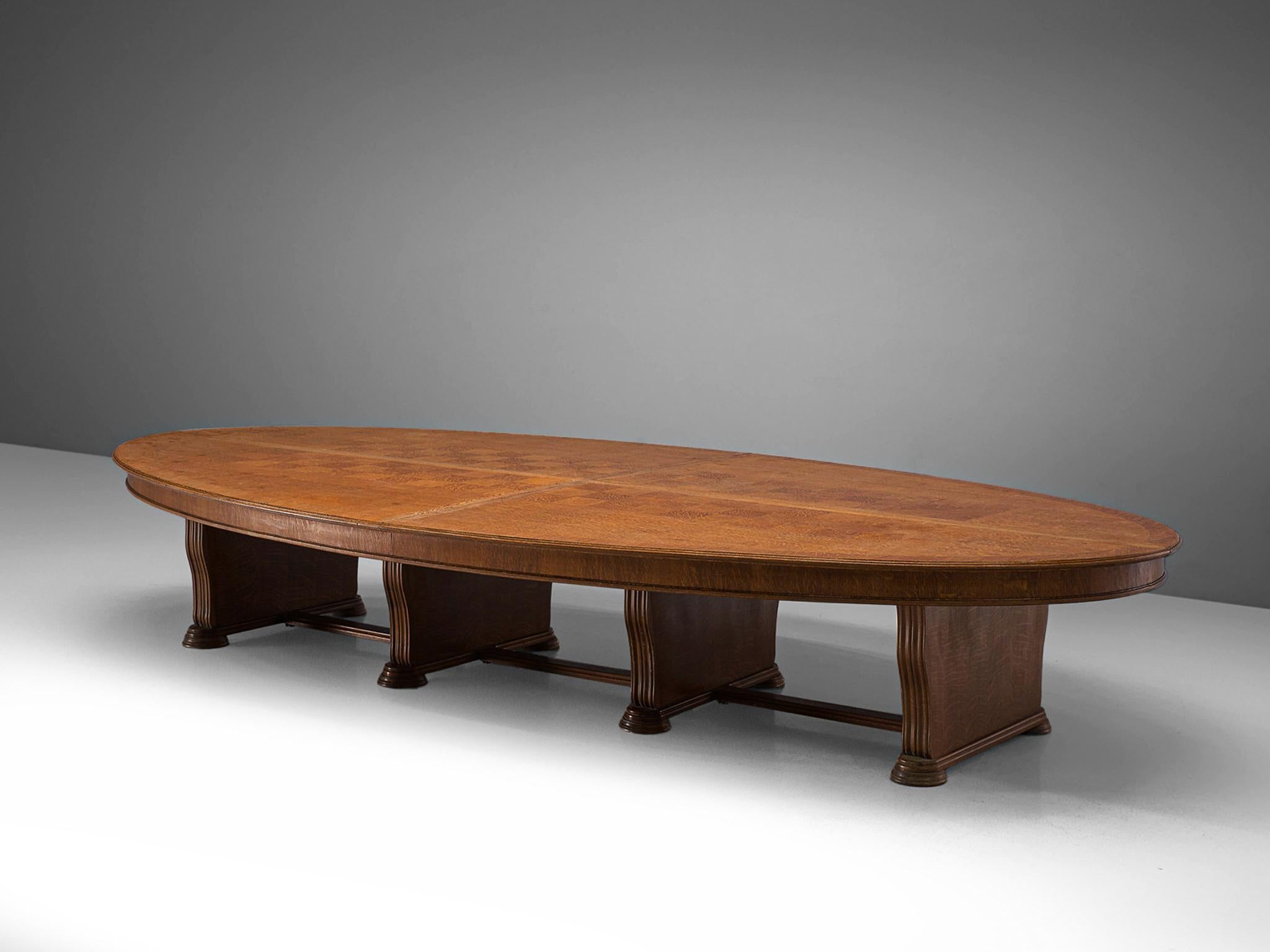 Conference or dining table, oak, Europe, 1950s. 

This robust dining table of considerable size holds stylistics traits of the Art Deco movement of the 1940s. The inlayed top with marquetry shows a beautiful checkered pattern that is created by