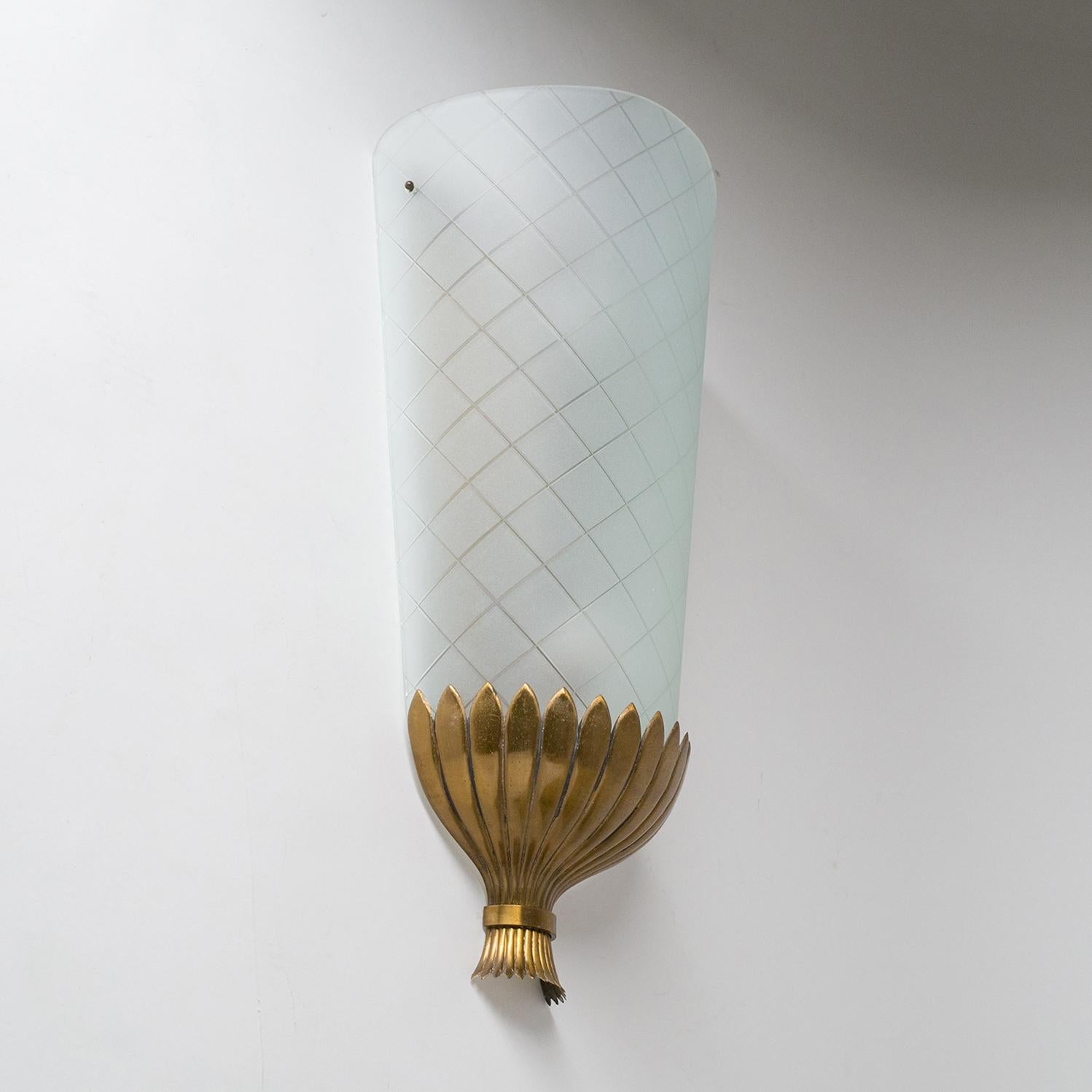 Rare oversized Art Deco wall light, from the 1930s. A large curved and satinated glass diffuser with geometric incisions sits on top of a lovely stylized brass bouquet. Very nice original condition with some patina on the brass. Two original brass