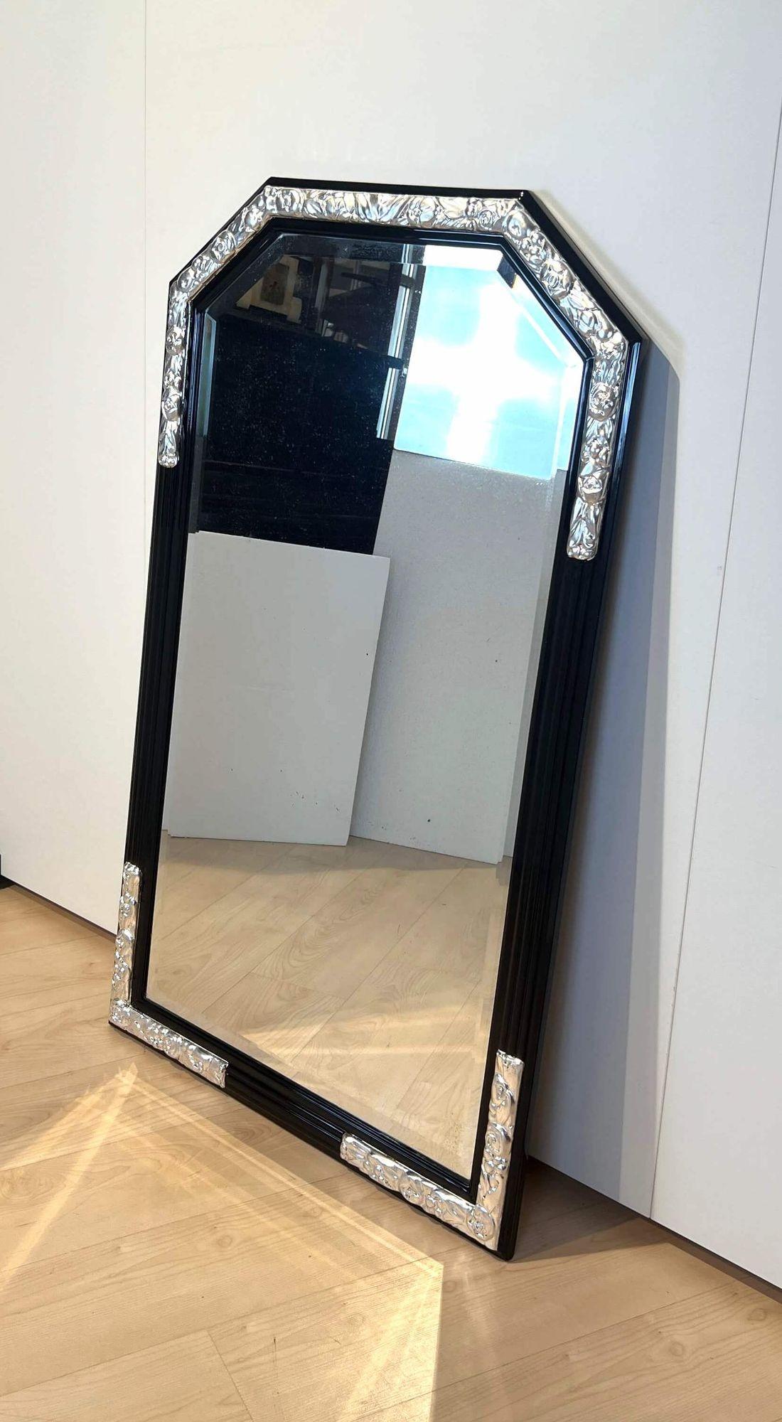 Large Art Deco Wall Mirror, Black Lacquer on Oak, Silver Leaf, France circa 1930.
 
Solid Oak, high gloss black lacquered. Original faceted glass. Floral ornaments covered with silver leaf and protective varnish.
 
Dimensions: H 134 x W 80 cm x D 4