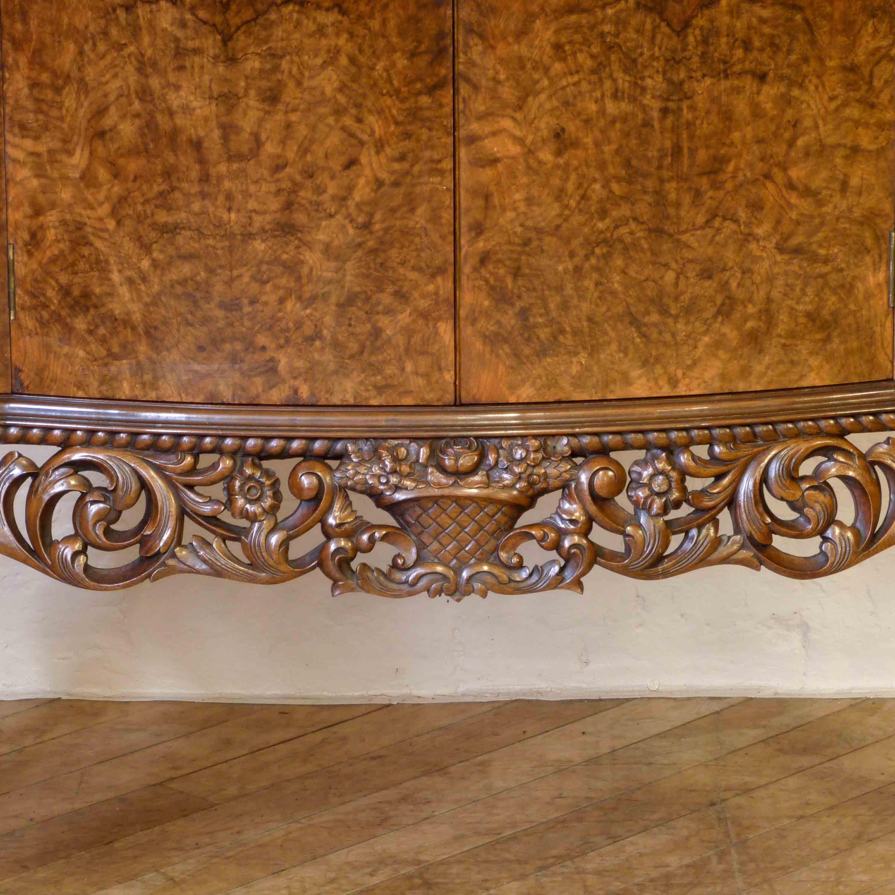 Magnificent burr walnut cocktail/drinks cabinet of large proportions. The base is heavily carved across it's apron as are the superb cabriole legs that terminate on taloned hairy feet. The upper section is more on the lines of Art Deco in style