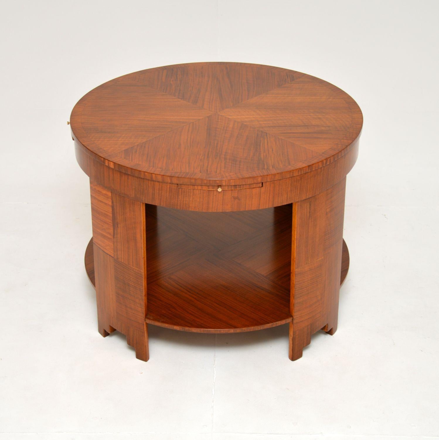 A stunning and large Art Deco walnut coffee table. This was made in England, it dates from the 1920’s.

It is of superb quality and is a most impressive size. The circular top has four brush slides that pull out from the edges with small brass