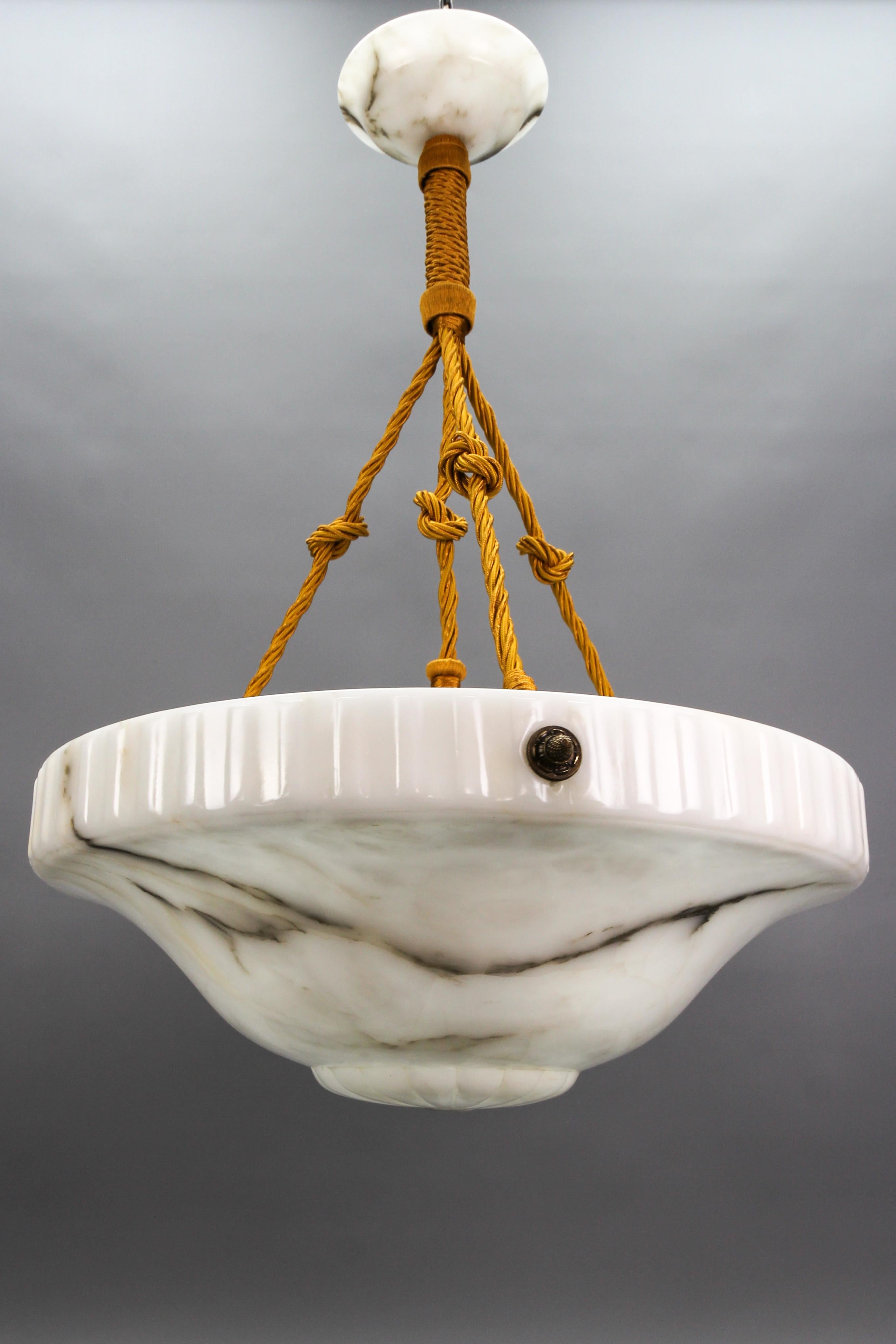 Large Art Deco white alabaster four-light pendant chandelier, Italy, circa the 1930s.
An impressive and beautifully shaped alabaster pendant light fixture from circa the 1930s. The large white alabaster bowl is suspended by ropes - wires with brass