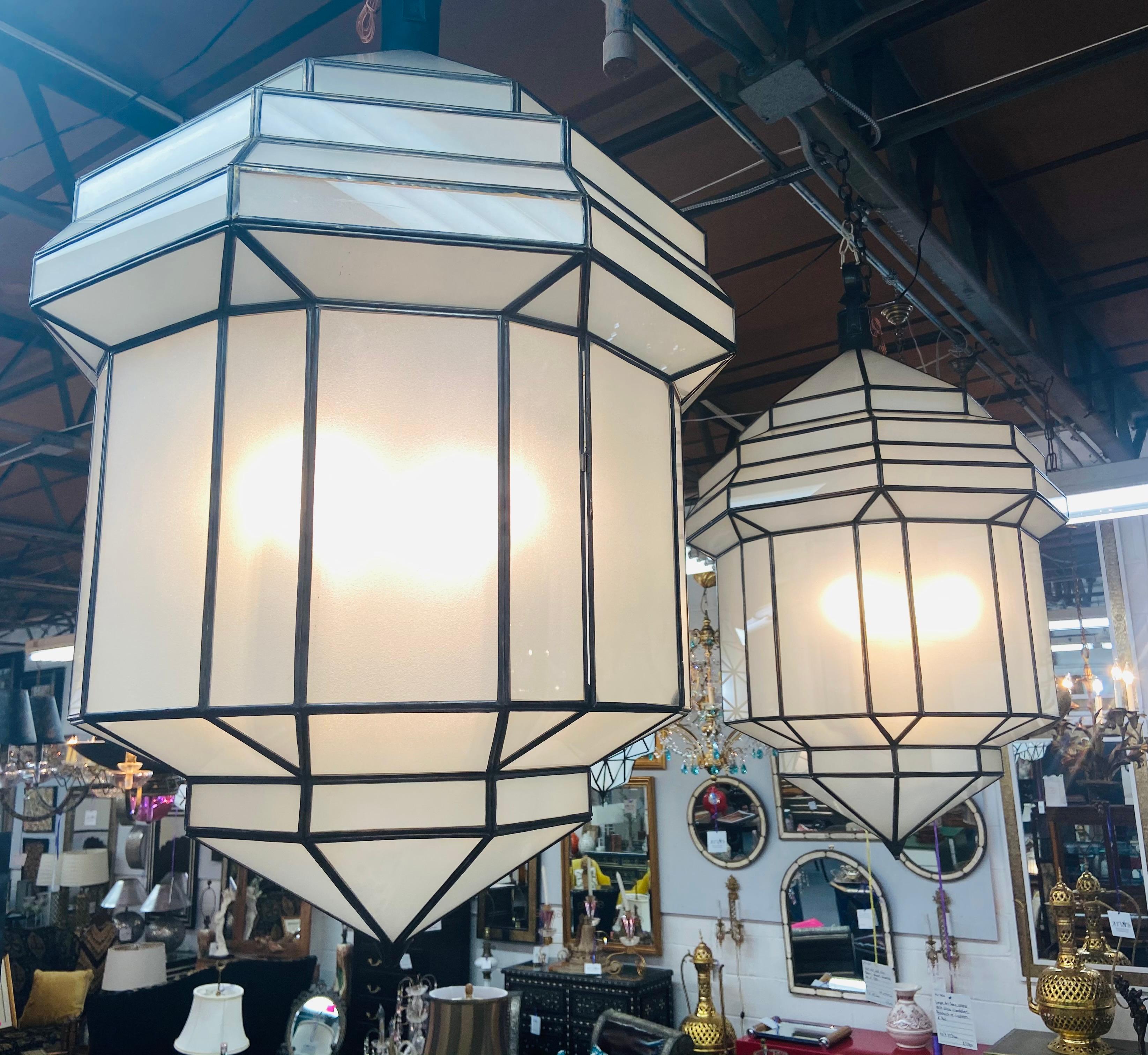 Large Art Deco white milk glass handmade chandelier, pendant, lantern, a pair

A gorgeous handcrafted, having individual panes, pair of large Art Deco hanging lanterns or ceiling fixtures featuring sandblasted frosted milky glass and patinated