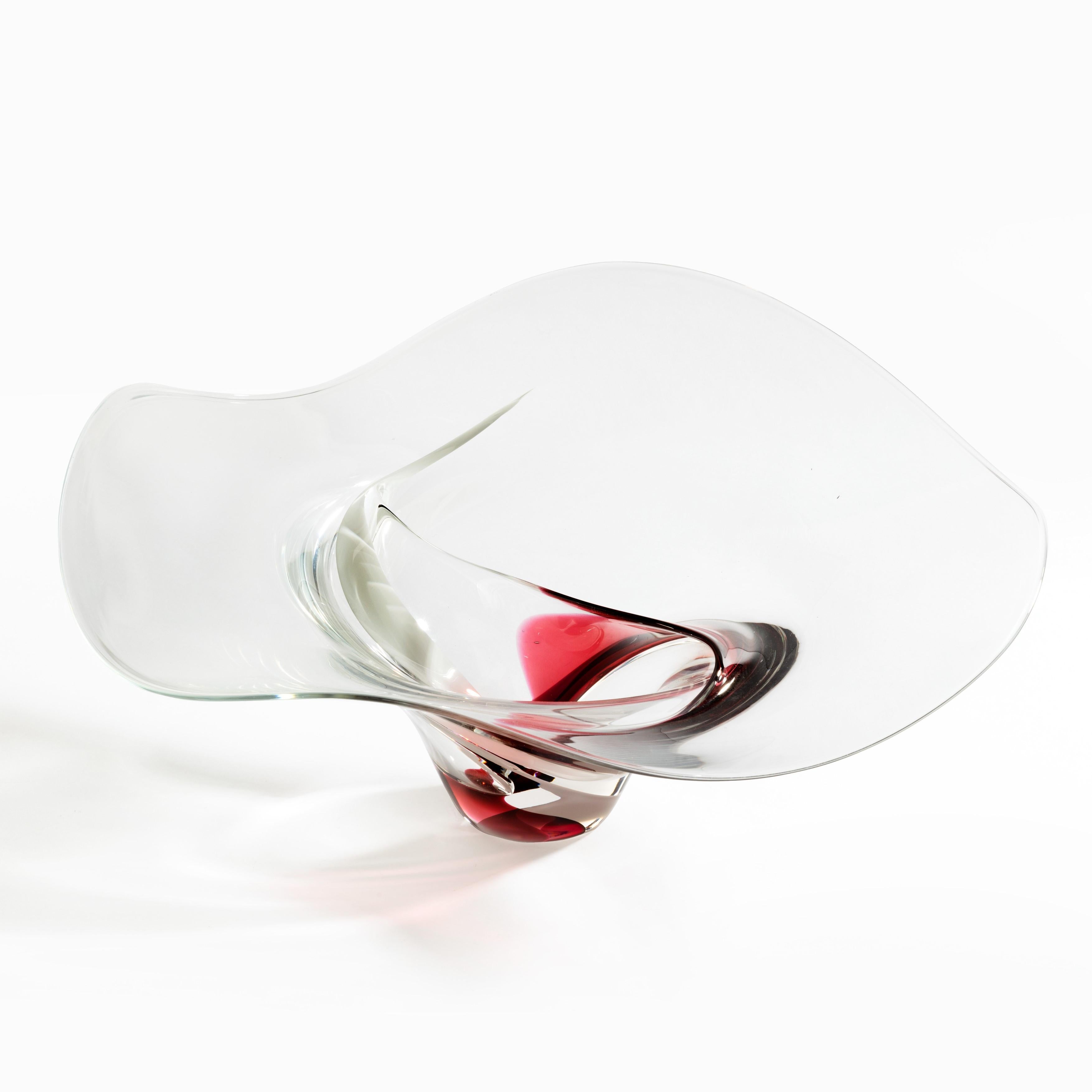 Una grande coppa in vetro artistico di Michael Bang, dalla forma circolare ondulata e a spirale, soffiata in vetro trasparente con due volute di pigmento bianco e rosso opaco. Scandinavo, fine del XX secolo.
 

Michael Bang (1942-2013)
Arte vetraria