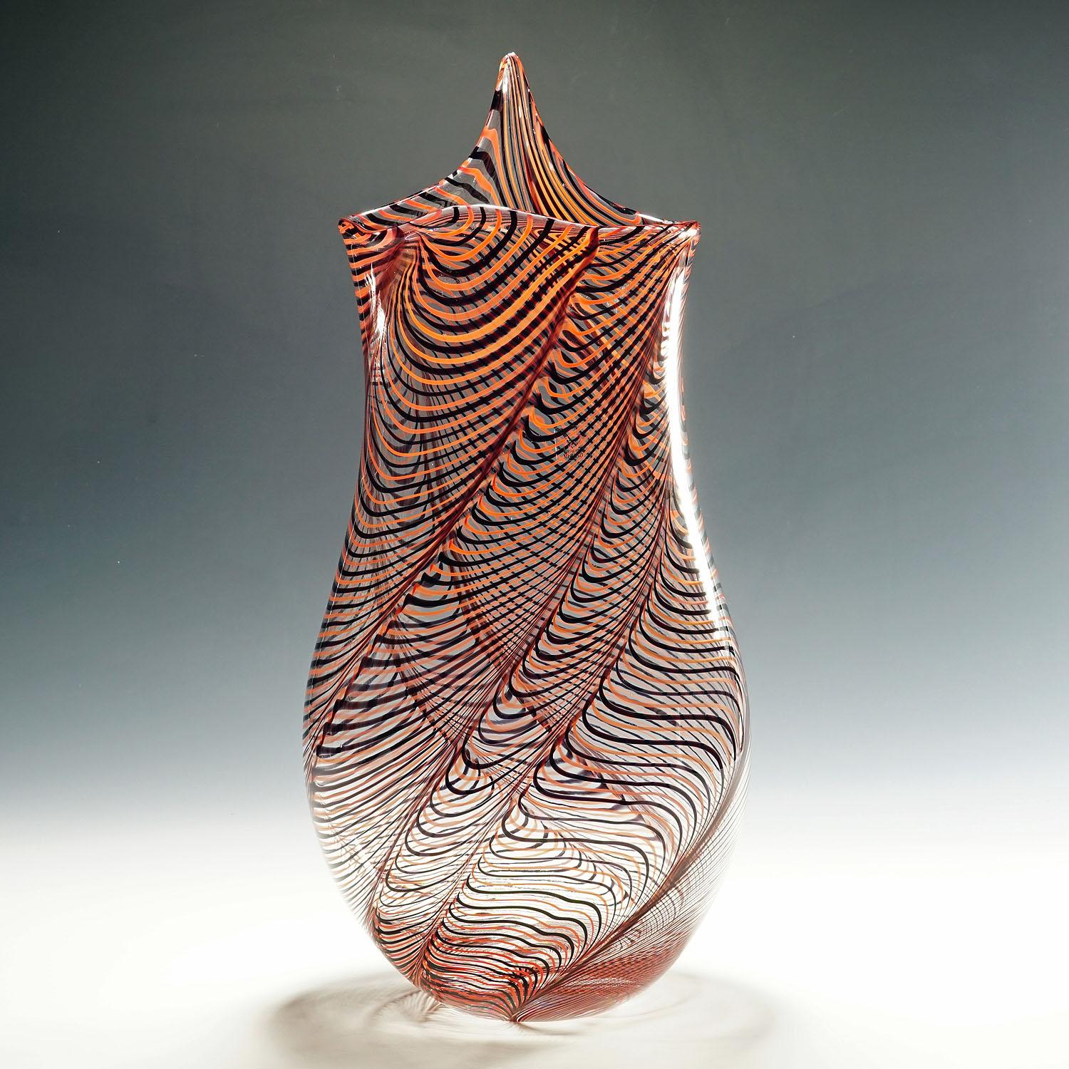 Large Art glass vase by Luca Vidal, Murano.

A large art glass vase handmade by glass master Gianluca Vidal early 2000s. Free formed clear glass body internaly decorated with red and black treads drawn in waves. Signed with 'Vetro Artistico Murano'