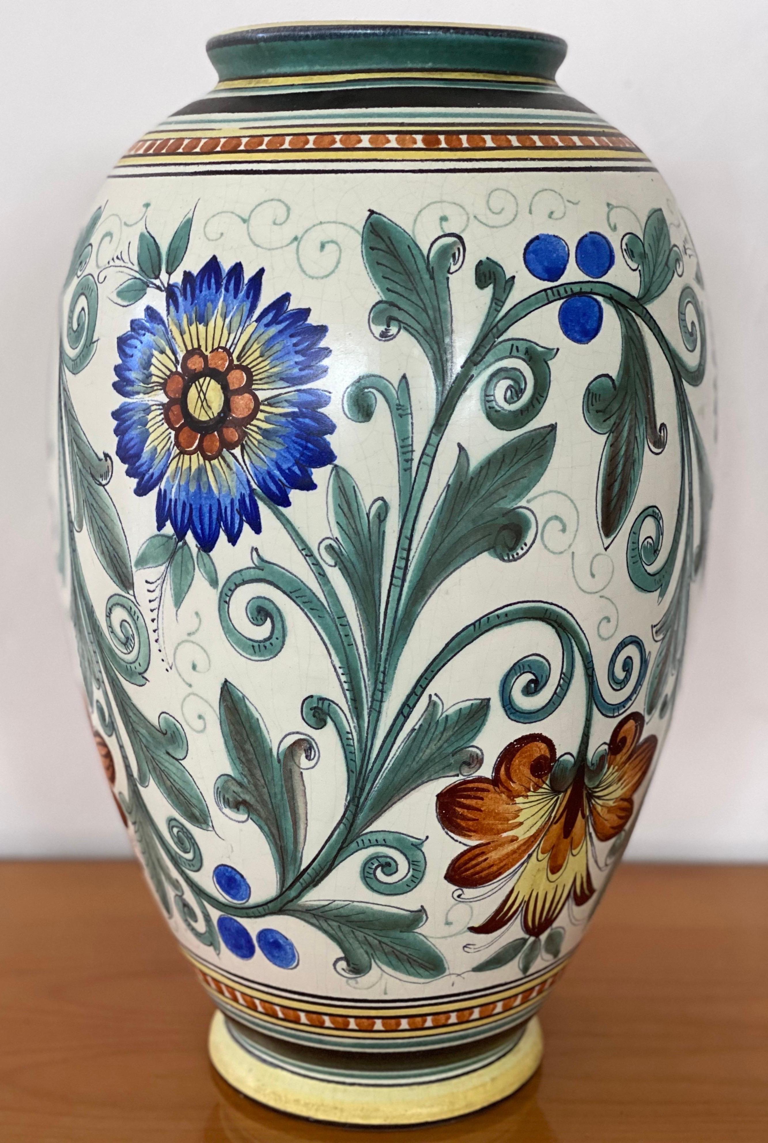 A large and excellent ceramic vase Zuid-Holland from Gouda manufactured in The Netherlands Art Deco period decorated in polychrome decor of flowers with colors in blue, green, yellow brown and white.