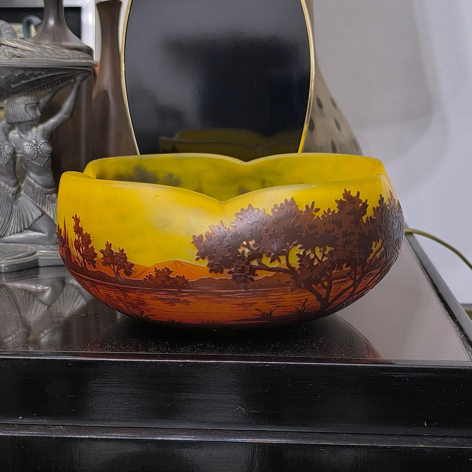 Daum Nancy, Francia. Grande ciotola in vetro multistrato, decorata con alberi in un paesaggio lacustre. 
Ciotola polilobata con triplo strato di vetro arancione, rosso e marrone, con una decorazione finemente incisa di un paesaggio lacustre