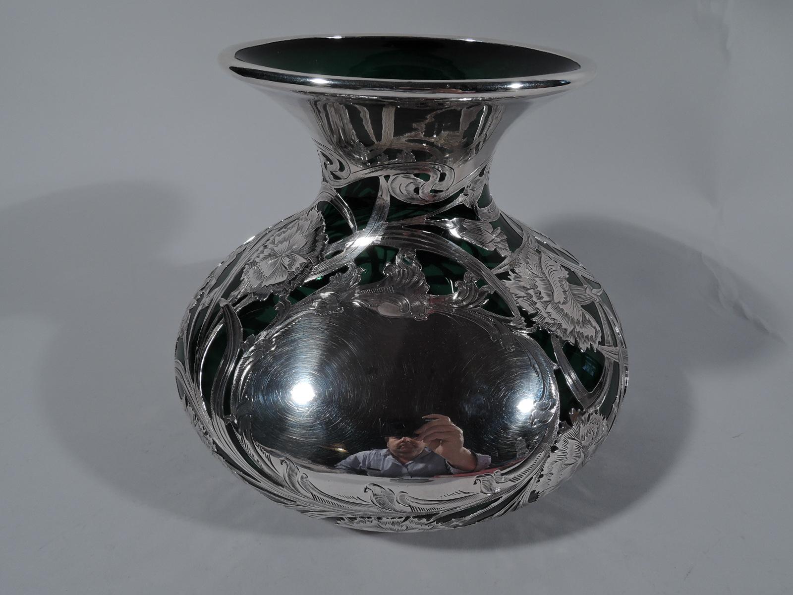 Large turn-of-the-century Art Nouveau green glass vase with engraved silver overlay. Made by Alvin in Providence. Bellied with short neck, flared rim, and wide mouth. Whiplash and interlaced tendrils and flower buds and blooms with serrated petals.