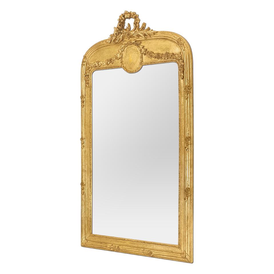 Grand miroir mural français ancien en bois doré de la période Arte Antiques mais dans le style inspiré de Louis XVI, vers 1910. Cadre de miroir ancien avec coquille et médaillon, décoré de nœuds floraux, de rubans, de guirlandes de fleurs, de perles
