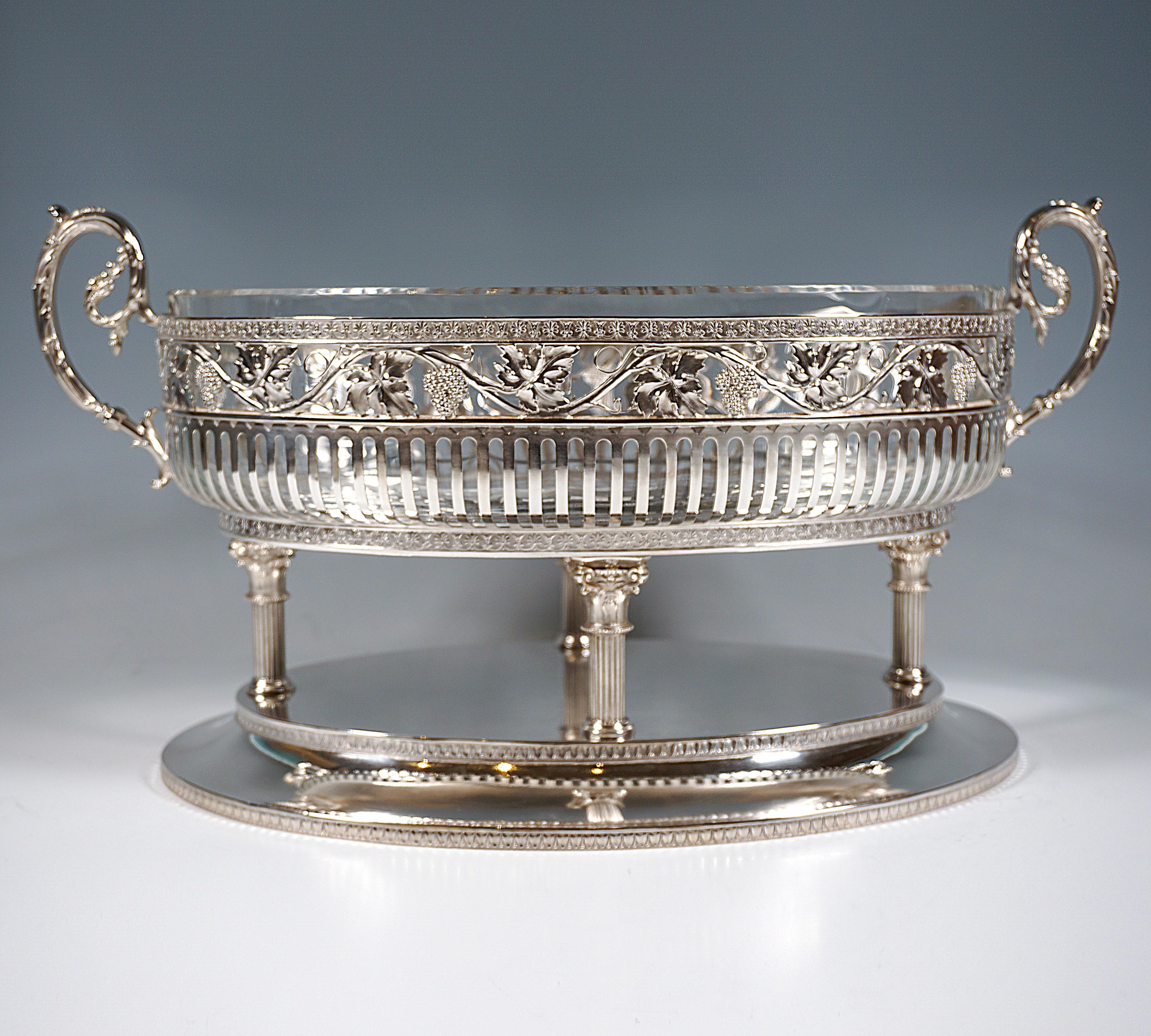 Representative elegant silver jardinière on oval, fluted stepped base, bordered by palmette bands, on top arranged in a lozenge four slender, fluted columns with Corinthian-like fancy capitals, crowned by a projecting oval bowl, the lower part is