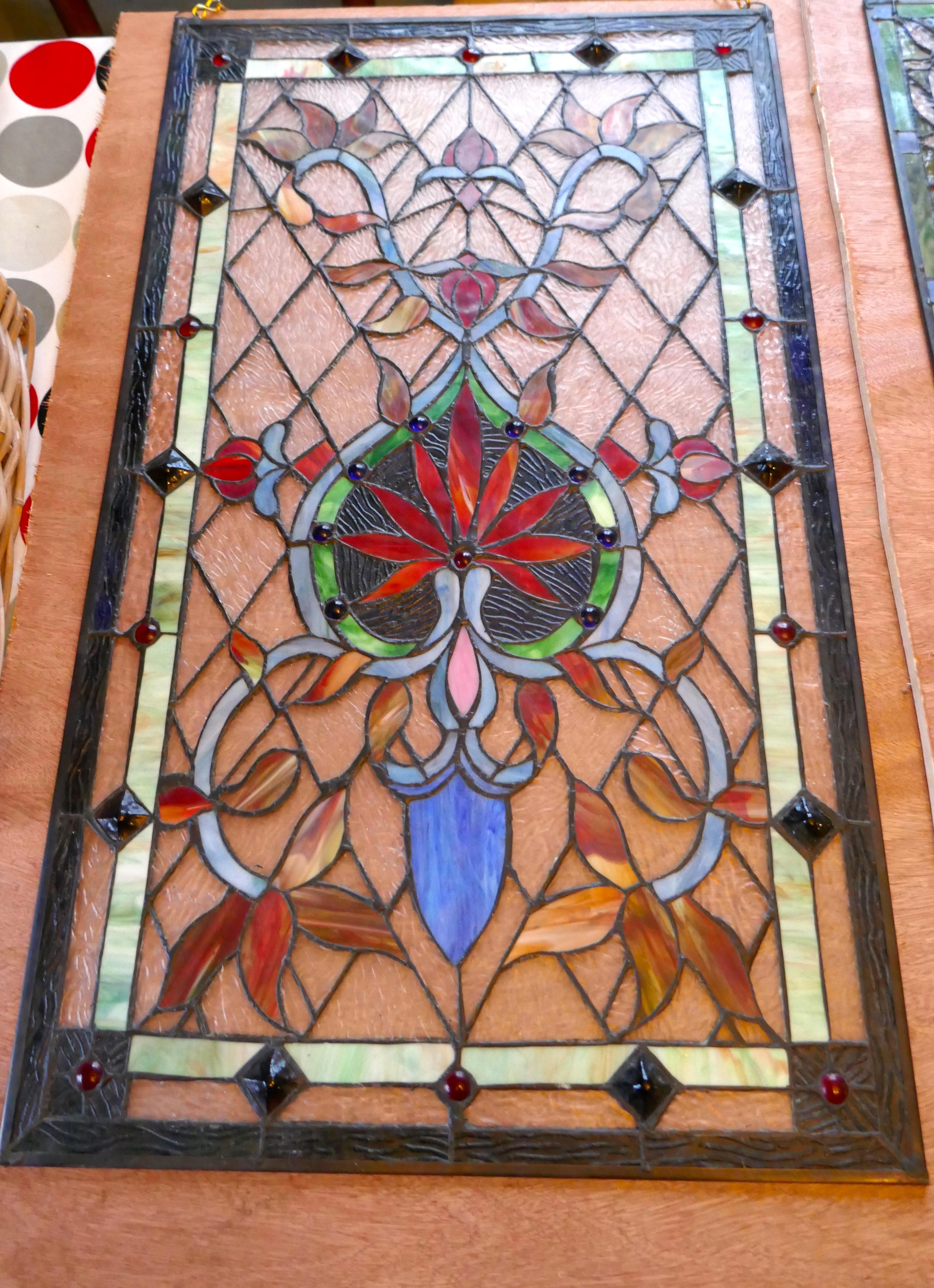 Large Art Nouveau stained glass panel for a window or door.

This is a 19th century piece, it has very attractive fine lead work outlining the stunning jeweled glass
The design of the panel shows a typical stylized Art Nouveau naturalistic