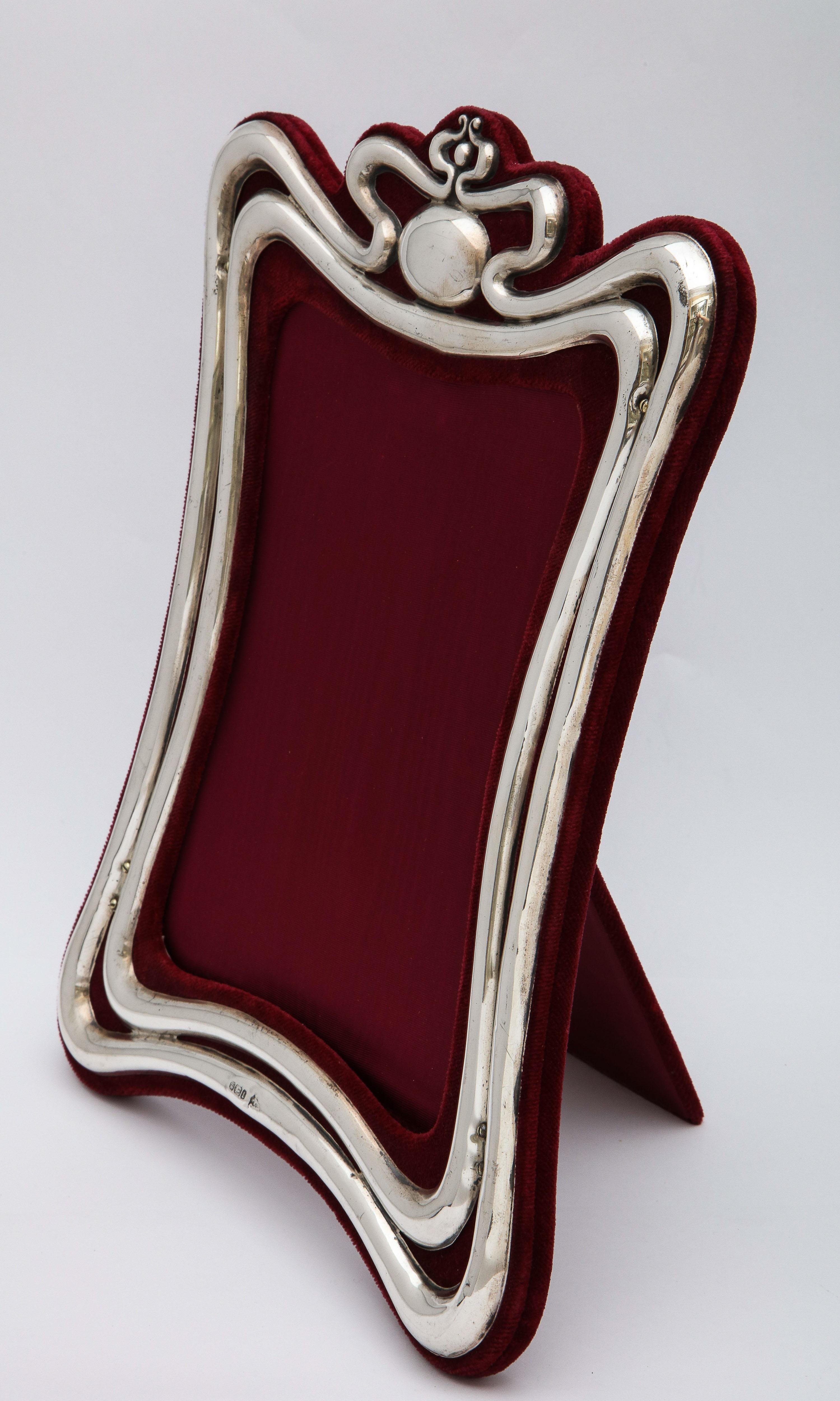 Large, Art Nouveau, sterling silver picture frame, Sheffield, England, 1903, Walker and Hall, makers. The sterling silver is mounted on deep burgundy velvet. The frame stands 11 1/2 inches high (at highest point) x 8 1/2 inches wide (at widest