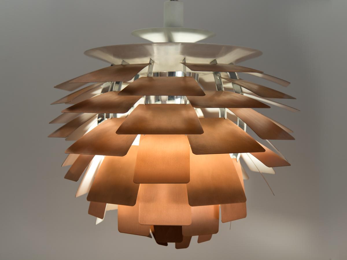 Monumental pendant lamp by Poul Henningsen for Louis Poulsen. Suspended by ivory enameled-steel canopy, the interior chrome cylinder is surrounded by layers of brushed copper leaves. Each brilliant leaf is configured so that the lamp emits a