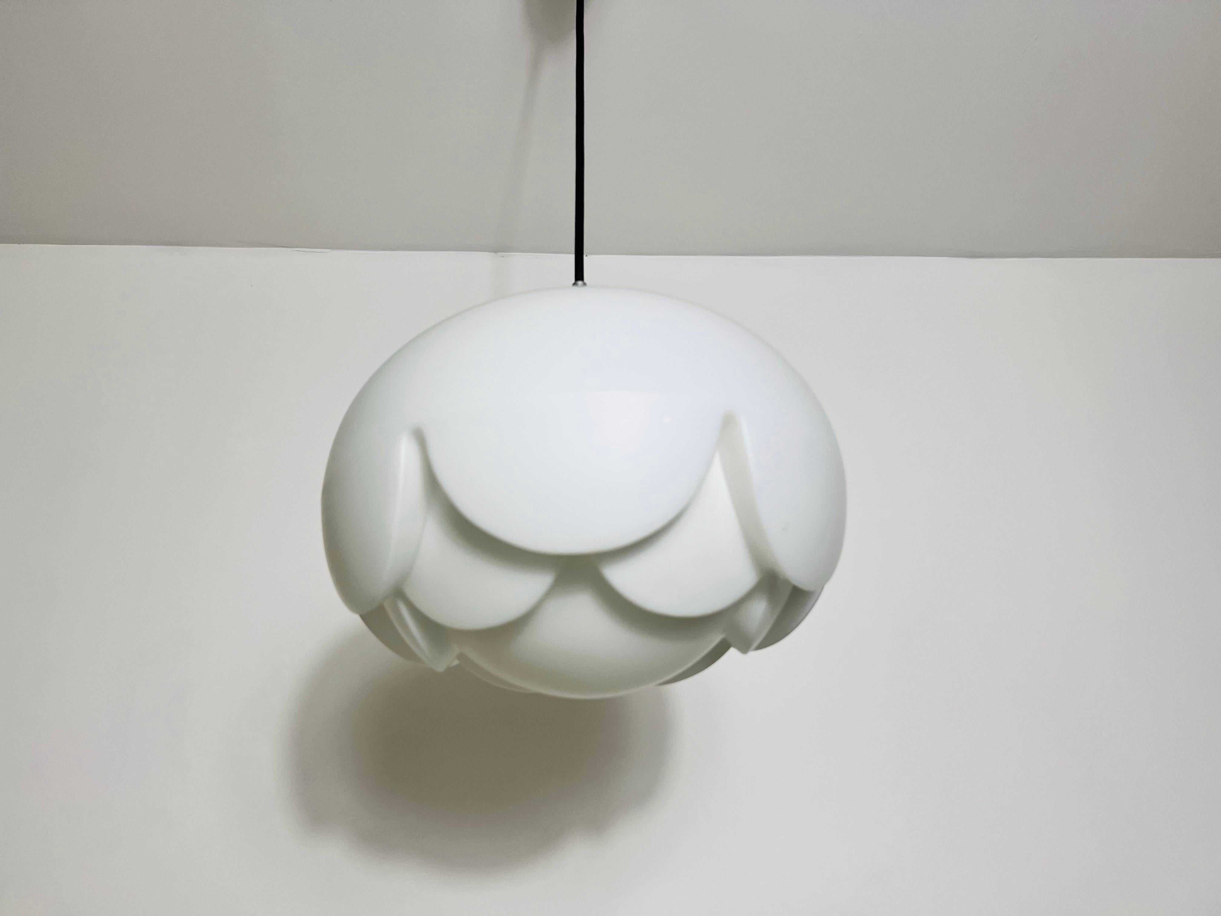 This hanging lamp by Peill & Putzler, made in Germany in the 1970s, is a striking example of contemporary design. Its form resembles an artichoke, adding a touch of elegance to any space. The lamp features captivating glass ornaments: the textured