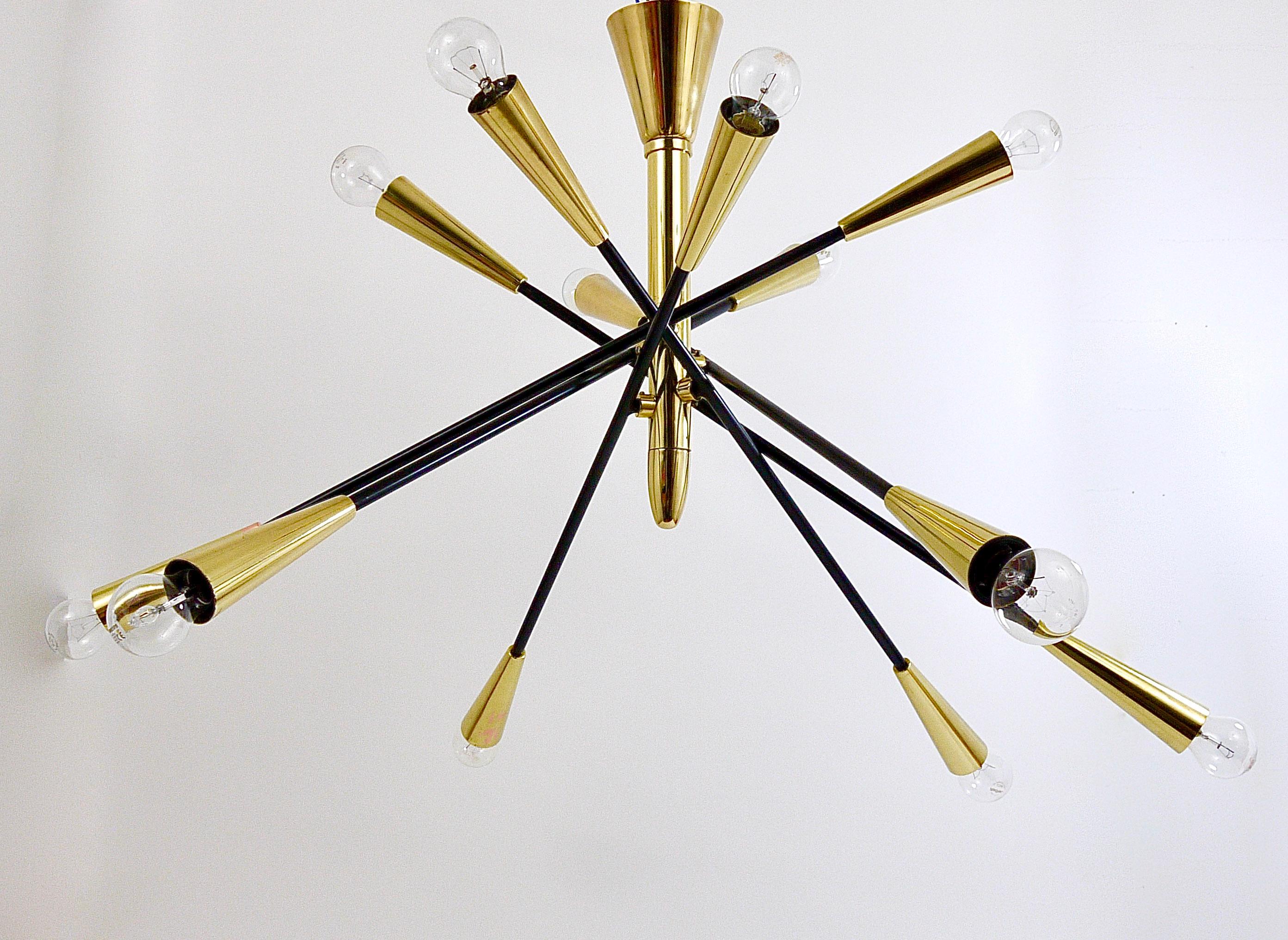 A large and impressive Italian midcentury Sputnik chandelier with articulating / adjustable arms from the 1950s. In the style of Stilnovo Italy. The light has a brass center base with six black-finished metal arms and cone-shaped sockets. The arms