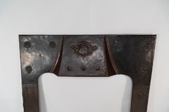 A large Arts and Crafts copper fire insert with a lion in a shield crest