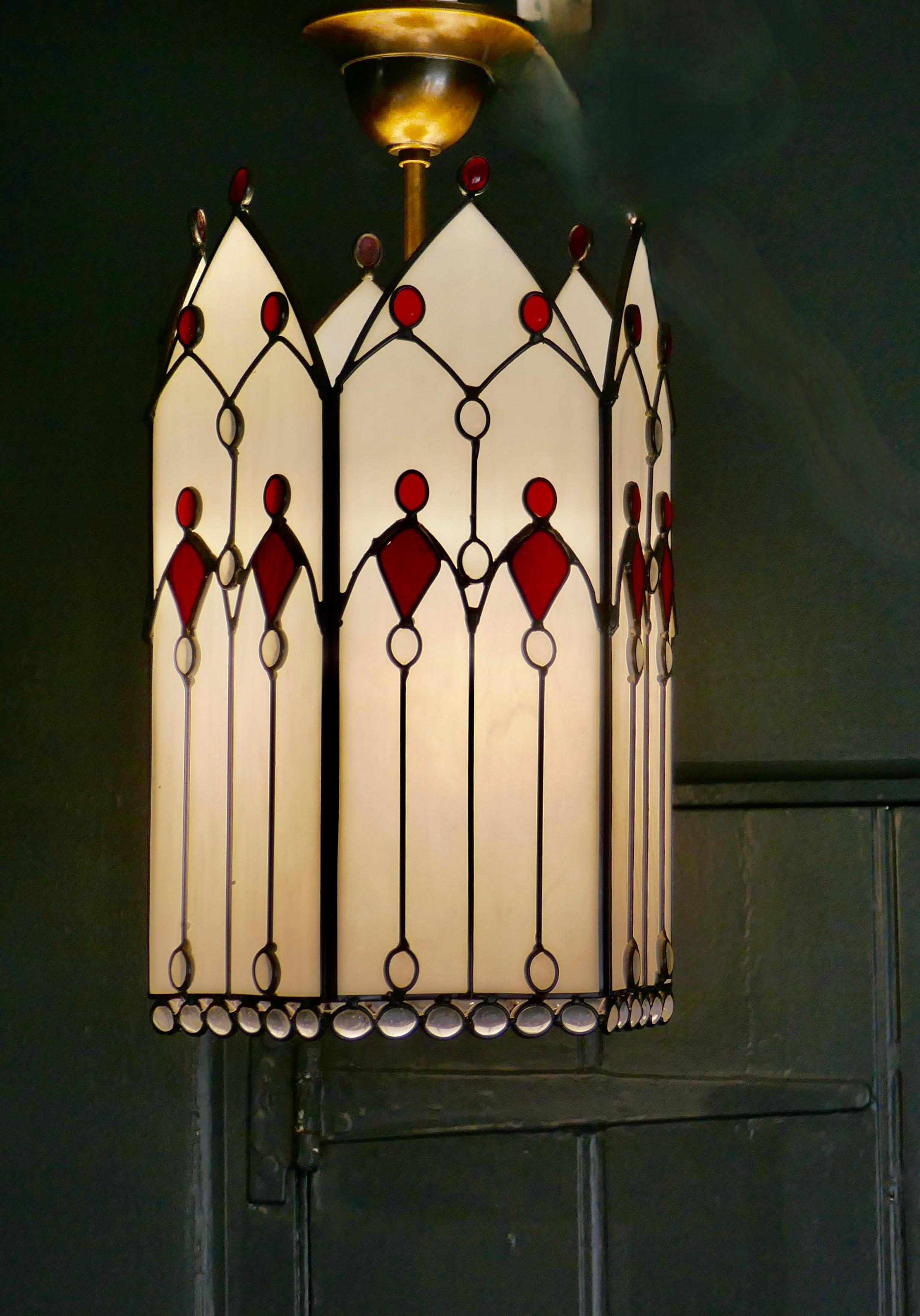 Large Arts and Crafts Stained Glass Hall Lantern Ceiling Light

This Large Hall Lantern is of Classic Arts and Crafts design, it has opaque leaded glass panels set with opaline and ruby glass into each of its 6 sides at the top of each there is