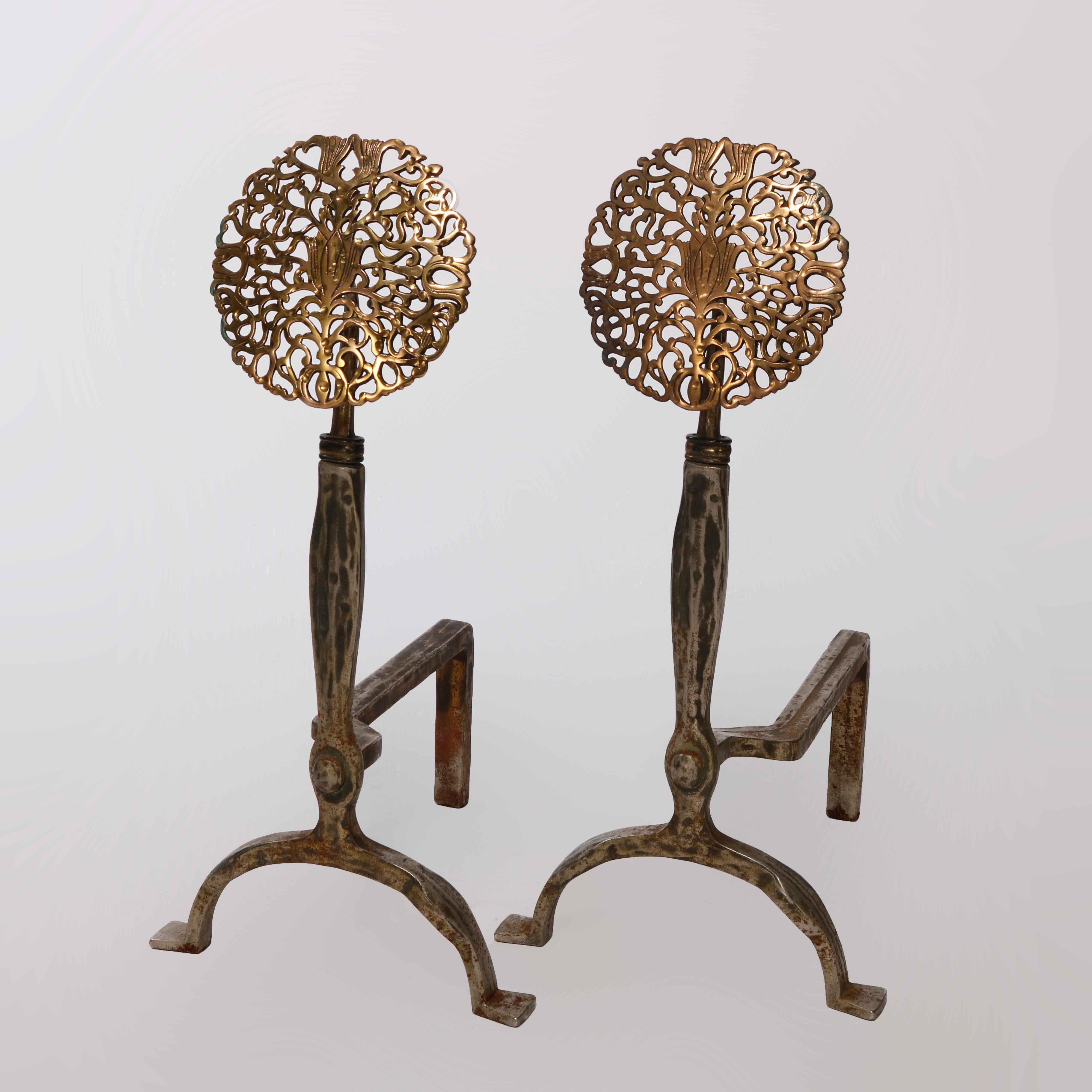 An antique pair of oversized Arts and Crafts fireplace andirons in the manner of Oscar Bach offer reticulated brass stylized sunflower finials over wrought iron bases, c1910

Measures - 27.5''H x 13.25''W x 15.5''D.

Catalogue Note: Ask about