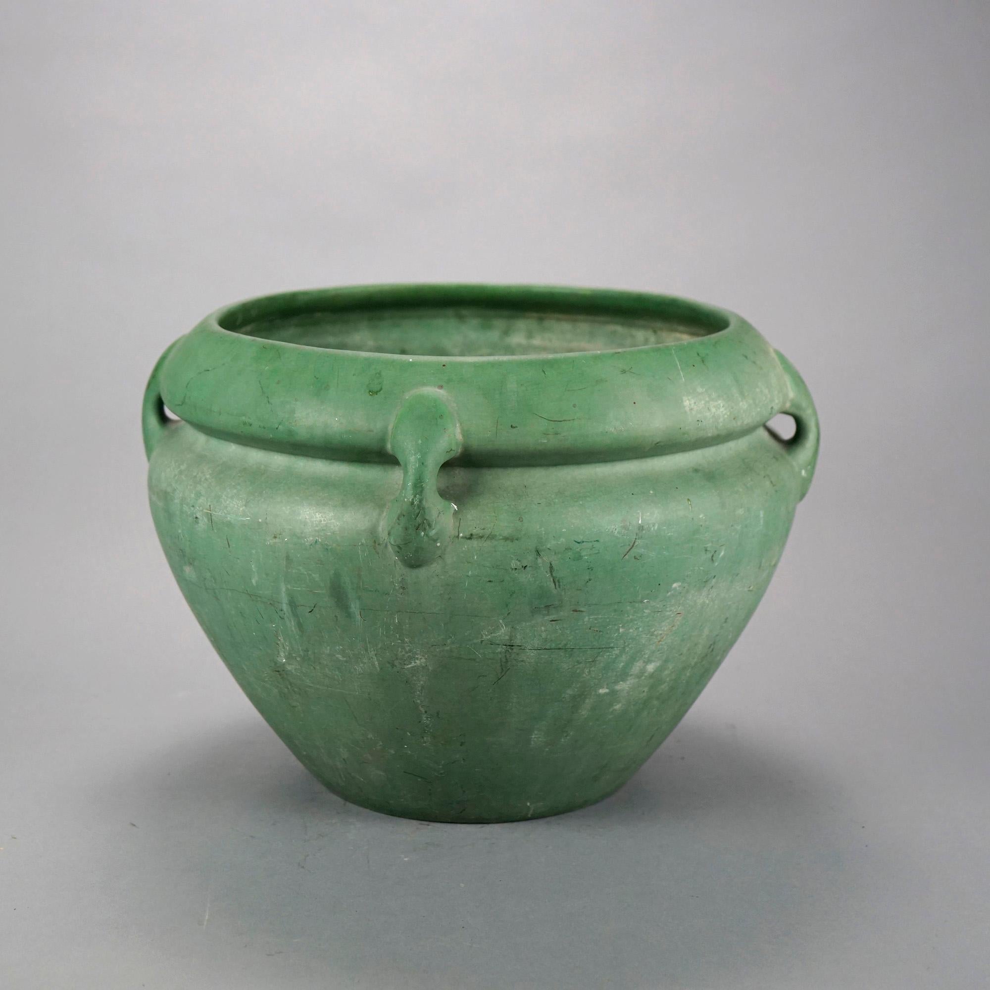 An antique Arts and Crafts jardiniere in the manner of Weller offers buttress form handles and matte green glaze, unmarked, c1910

Measures- 10.75'' H x 14.5'' W x 10'' D.