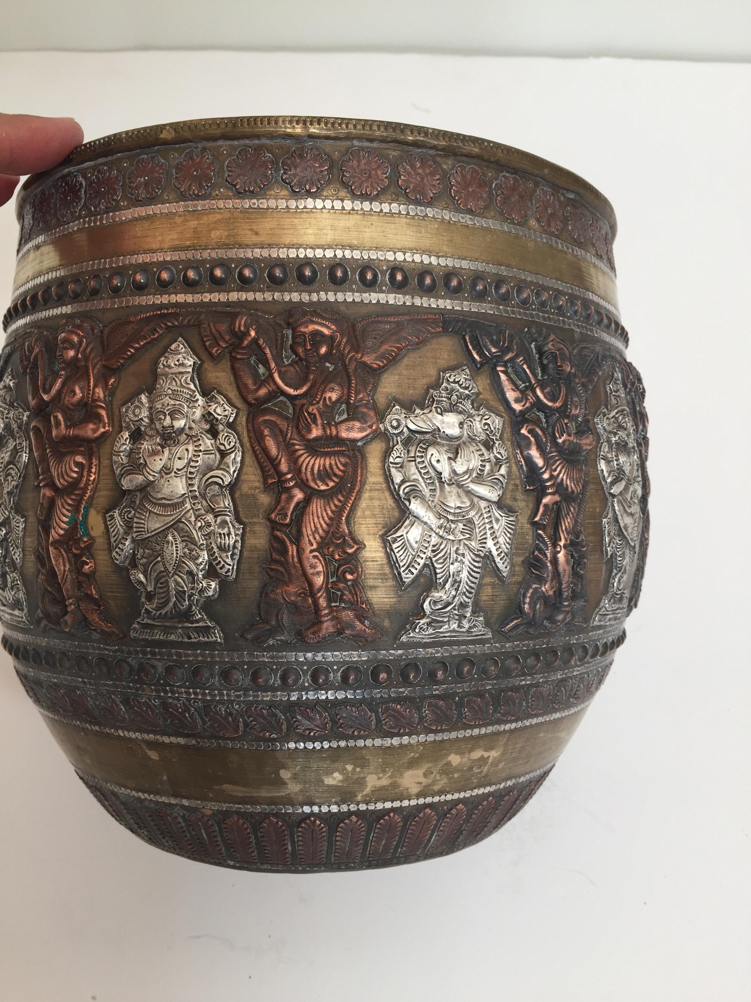 Large Asian Burmese brass ceremonial bowl with silver and copper inlaid with the ten Hindu Avatars of Vishnu.
Fine example of Tanjore work, this brass bowl that has been overlaid with alternating copper and silver chased plaques, with high quality