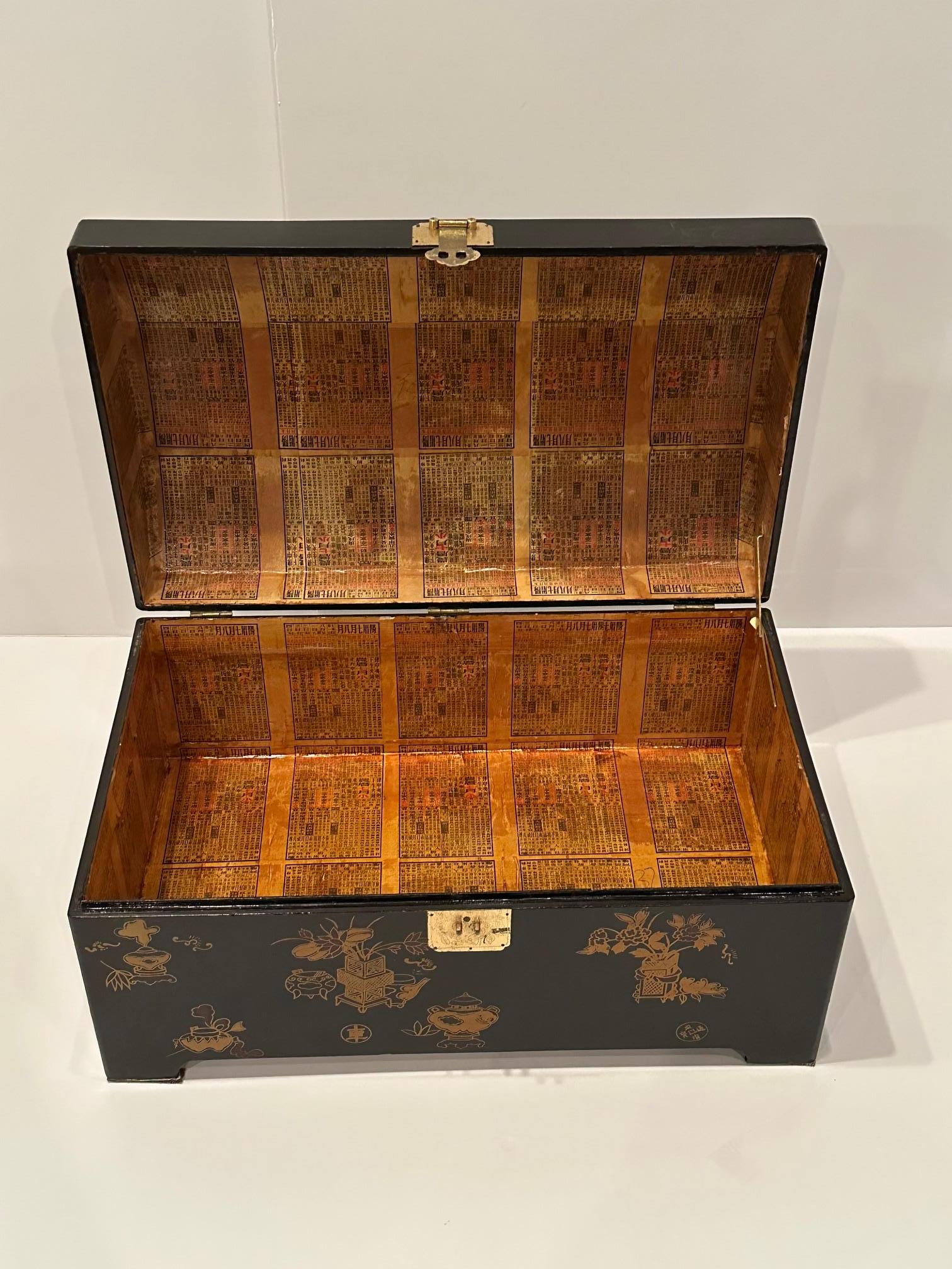 Beautiful large black lacquer Asian chest having dome shaped top, detailed figural decoration, brass latch and interior lined with Chinese wallpaper.