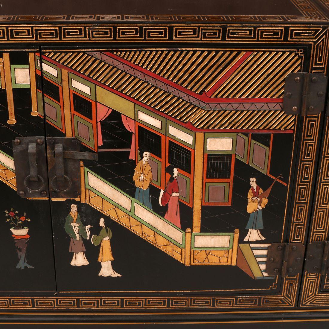 This large Asian hand-painted credenza features intricate carved Chinoiserie motifs, highlighting traditional scenes and patterns. The rich design is accented by bold colors of red and black and fine detailing, giving it a striking presence. With