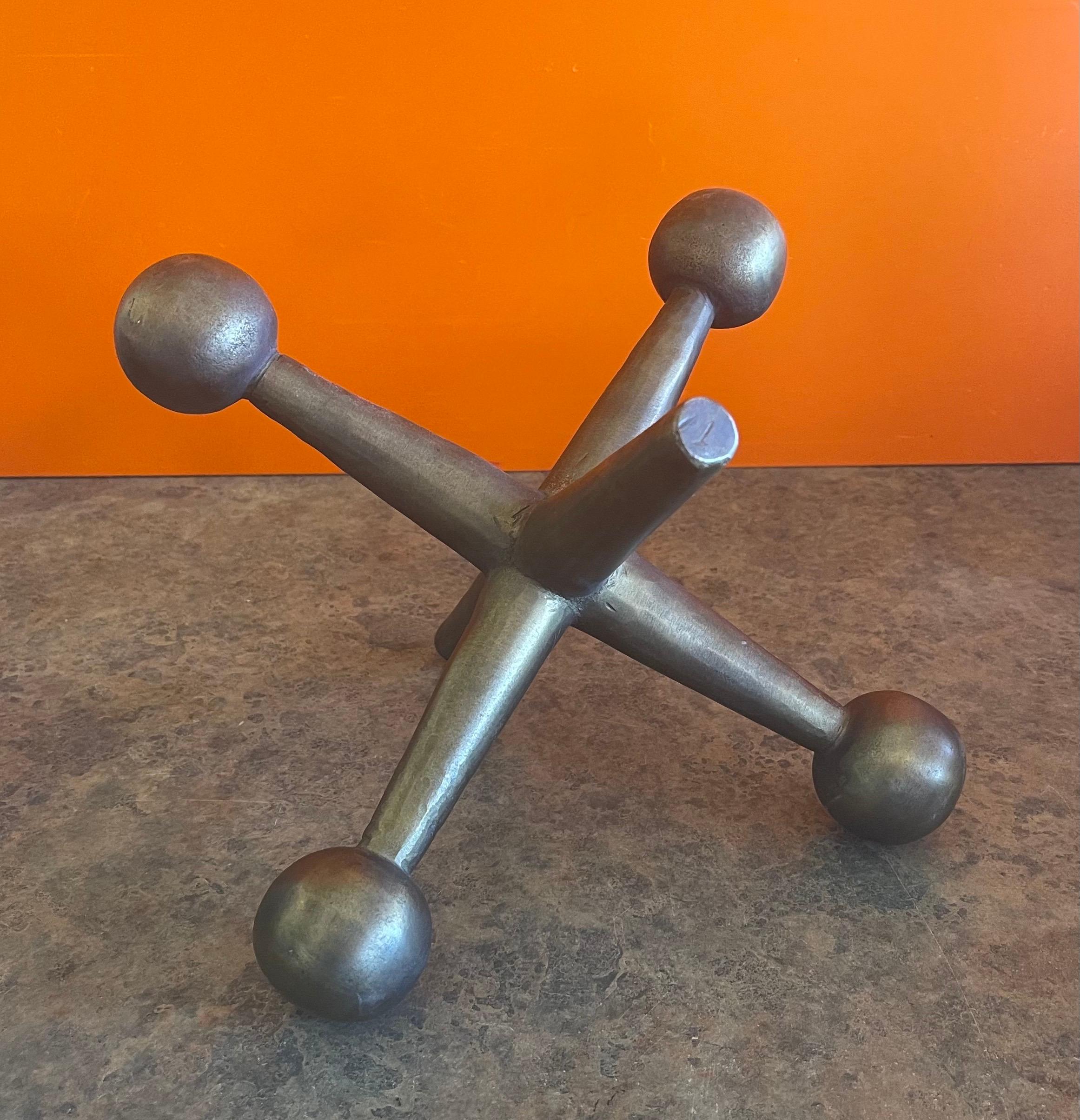 Vintage atomic era, mid-century modern large iron jack / jax in the style of Bill Curry, circa 1970s. The piece is functional as either a bookend, door stop or decorative accent and has a nice well worn metallic patina; it measures 9.5