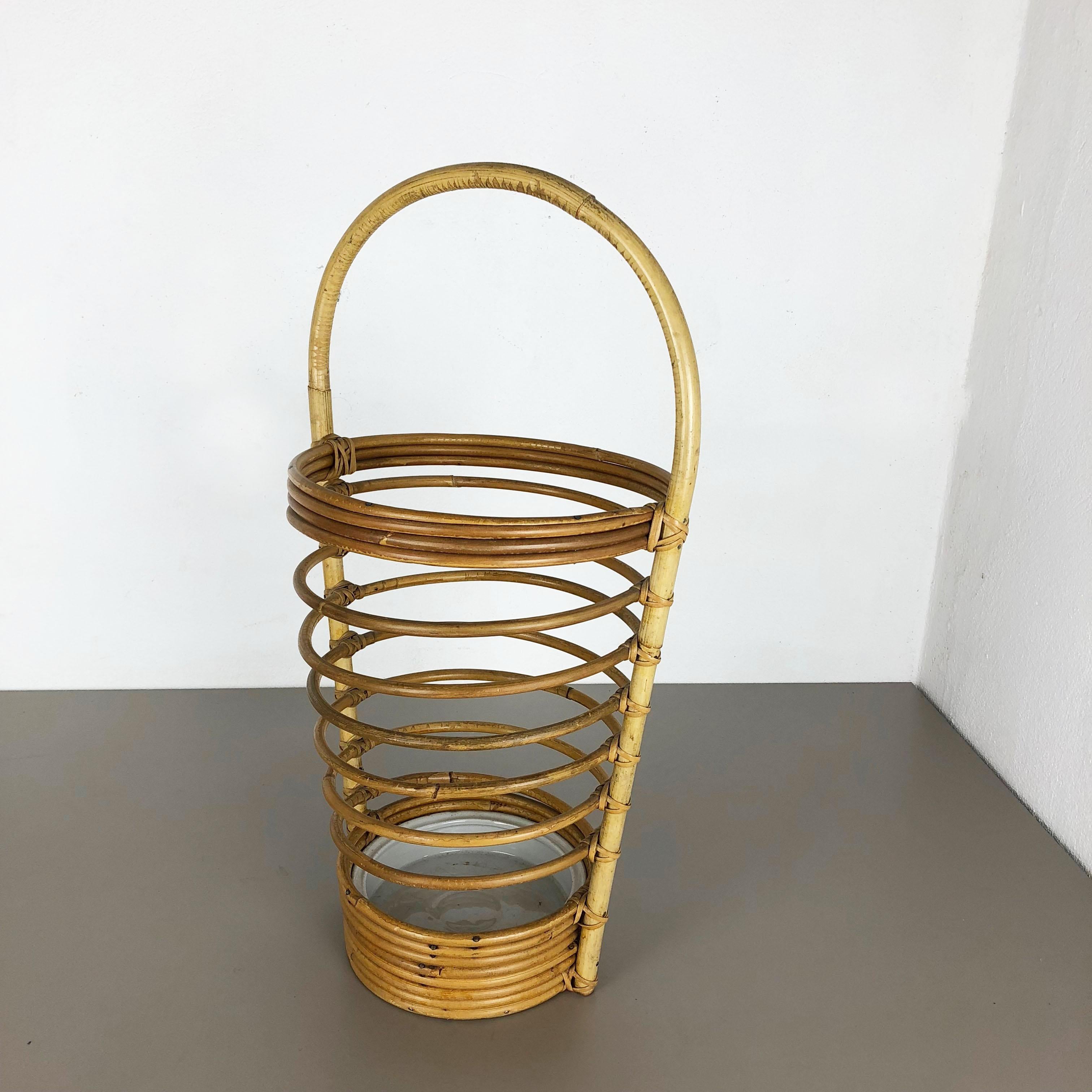 Article:

Umbrella stand


Origin:

France



Age: 

1970s


This original vintage Bauhaus style umbrella stand was produced in the 1970s in France. It is made of natural rattan with a loop handle element at the top. This item has a fantastic look