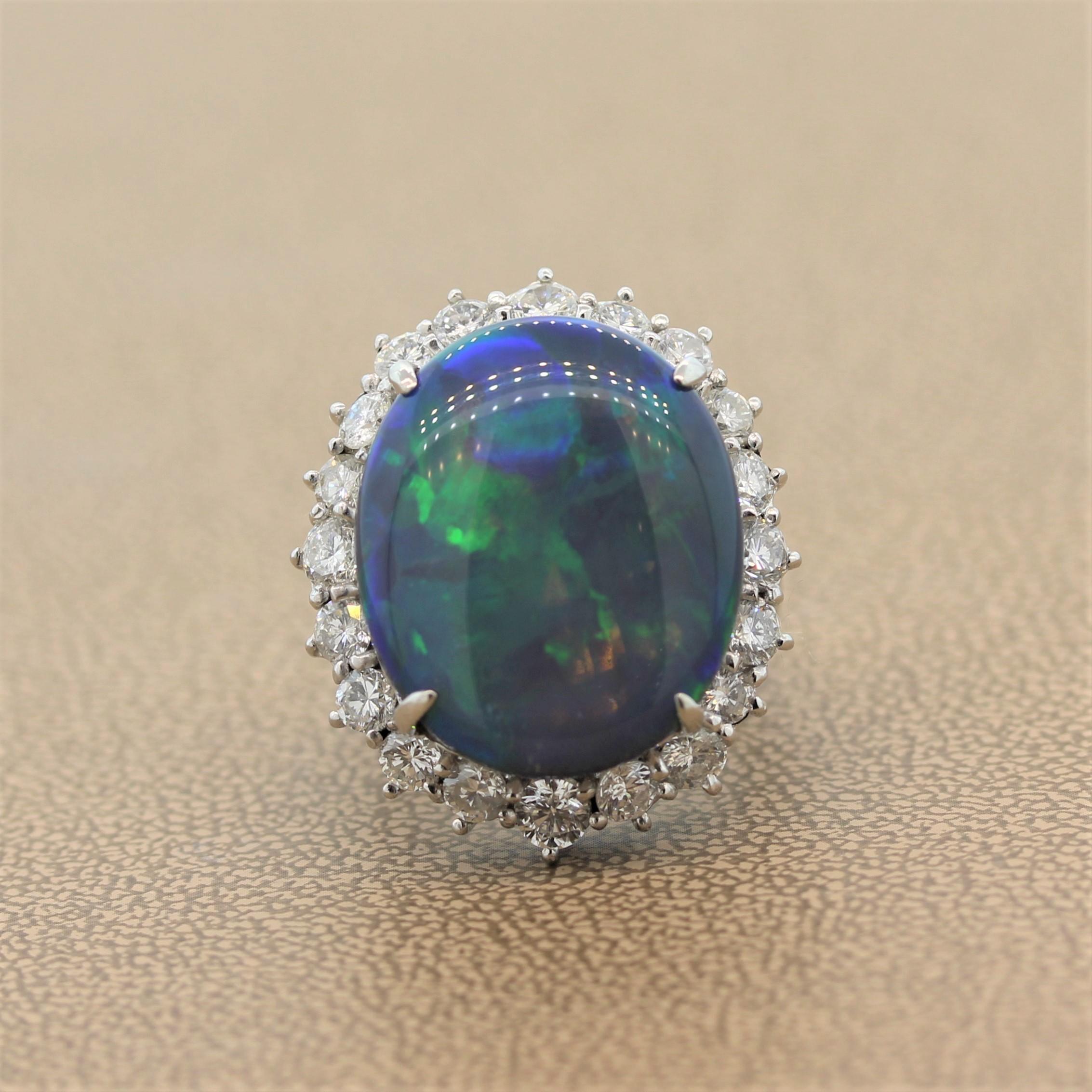 Make a statement with this astounding cocktail ring featuring a 19.86 carat Australian opal showing strong play of color with flashes or blue green and other colors. The oval shaped opal is haloed by 2.46 carats of round cut diamonds in a platinum