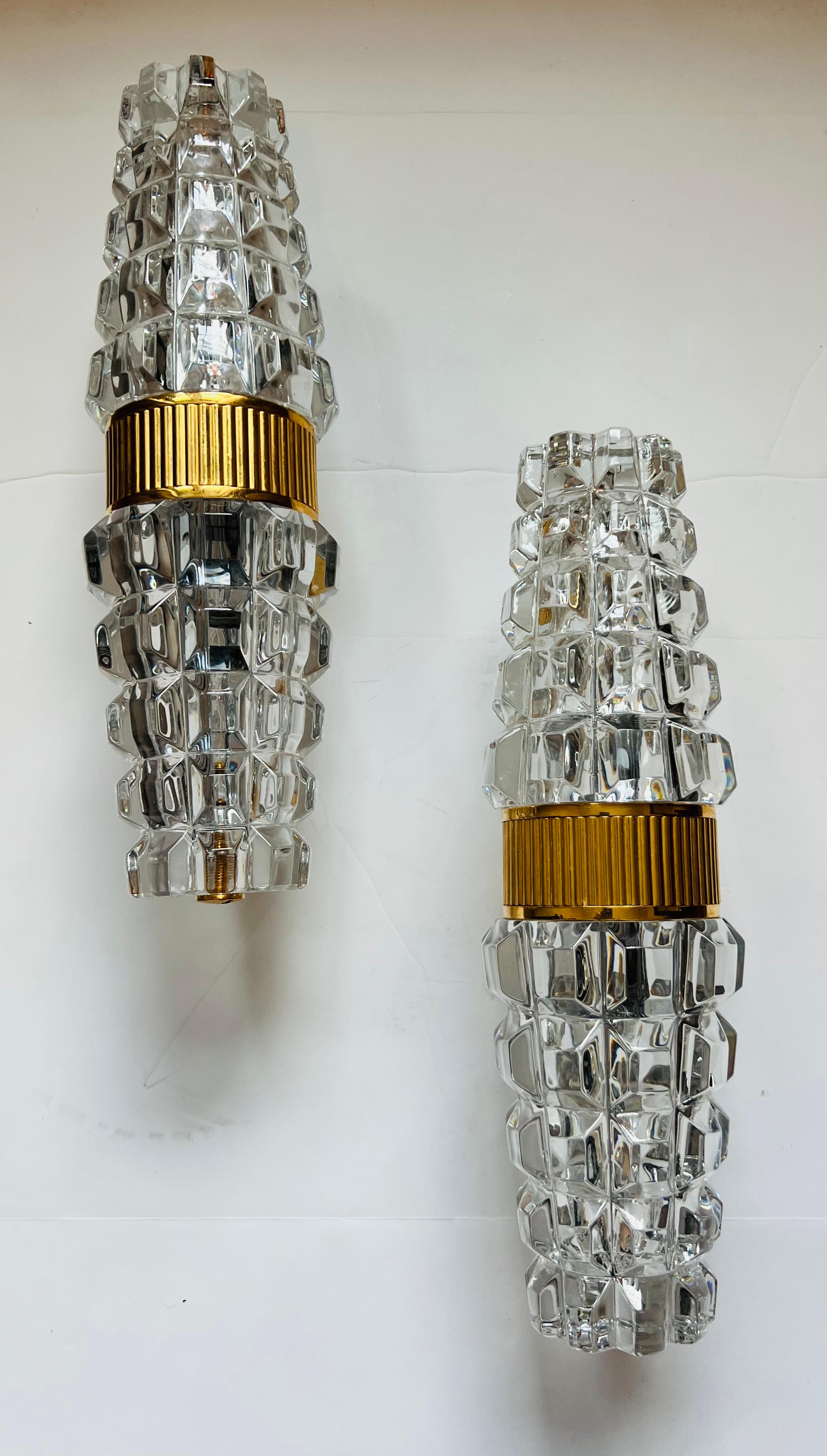 A luxurious heavy pair of Austrian crystal wall lamps with a gold plated fixtures made in the 1980s by Kolarz Leuchten. Rewired. Rare. Two light candelabra light sockets.