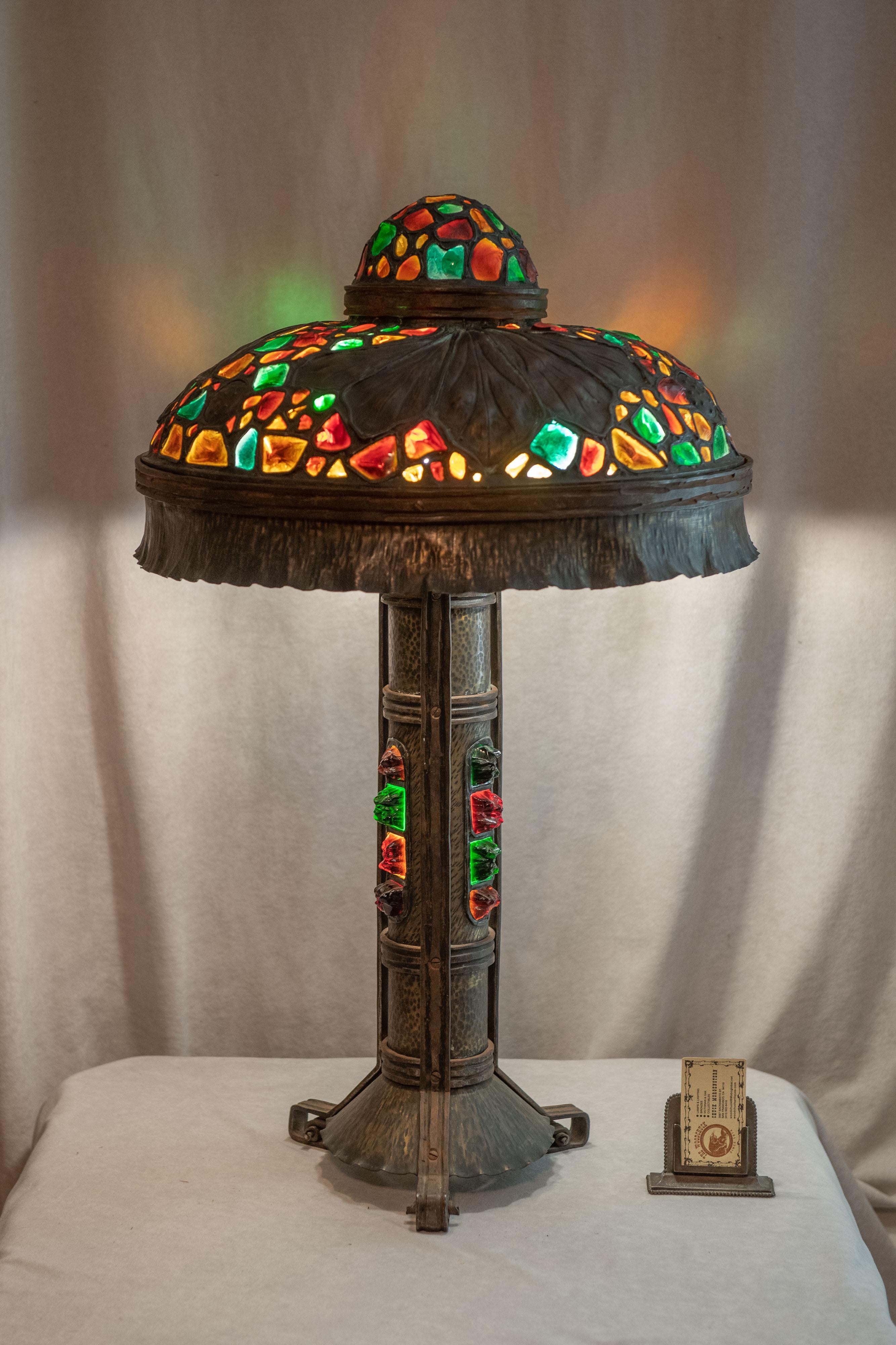 We have sold many Austrian table lamps with chunk jewel glass, but this may well be the best we have ever offered. Besides the extra large size, the design, the jeweled base, and the hammered metal work, it's most striking and colorful. The top of