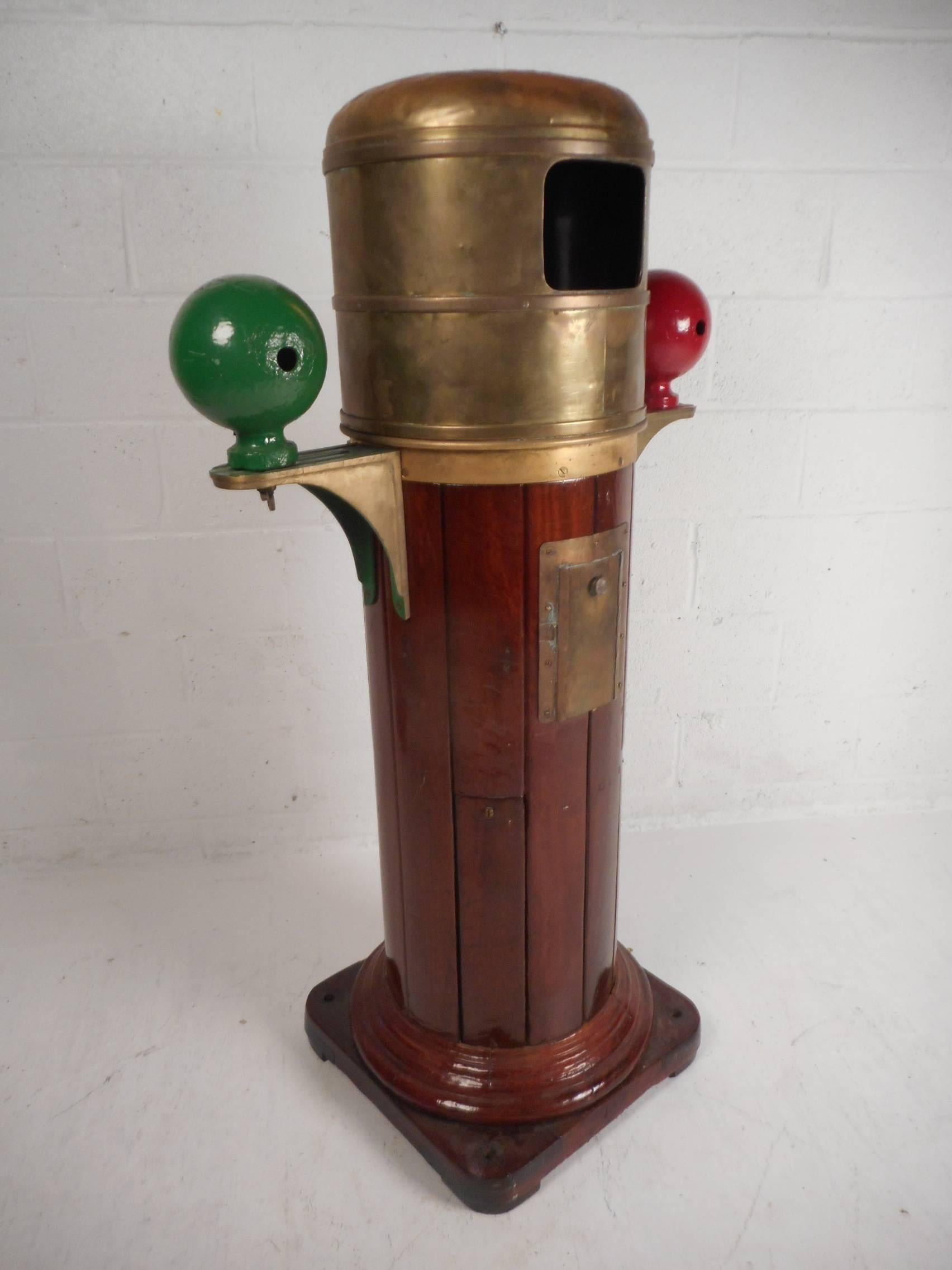 This wonderful vintage binnacle has a Kelvin and Hughes limited compass that sits comfortably underneath the brass top. Cylindrical teak case with two side mounted compensation spheres and a lamp housing on the back. This once functioned on a real