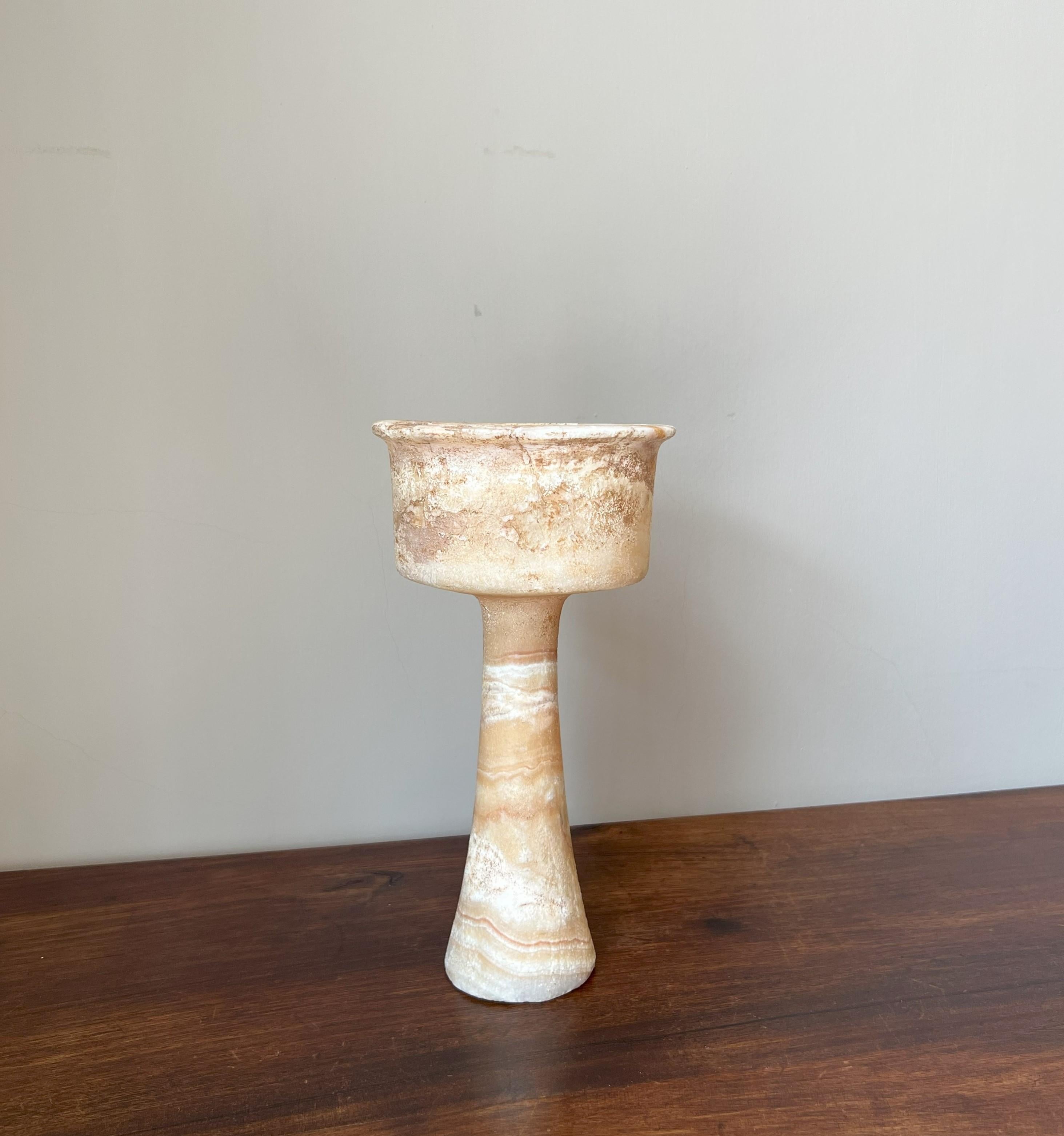 Bactrian alabaster chalice, circa 3000-2000 BC. It has an elegant tapering formed base with a undeep rimmed cup. The alabaster is strikingly vained. There are some old restaurations visible which blend in well. As time and coincidence shaped its