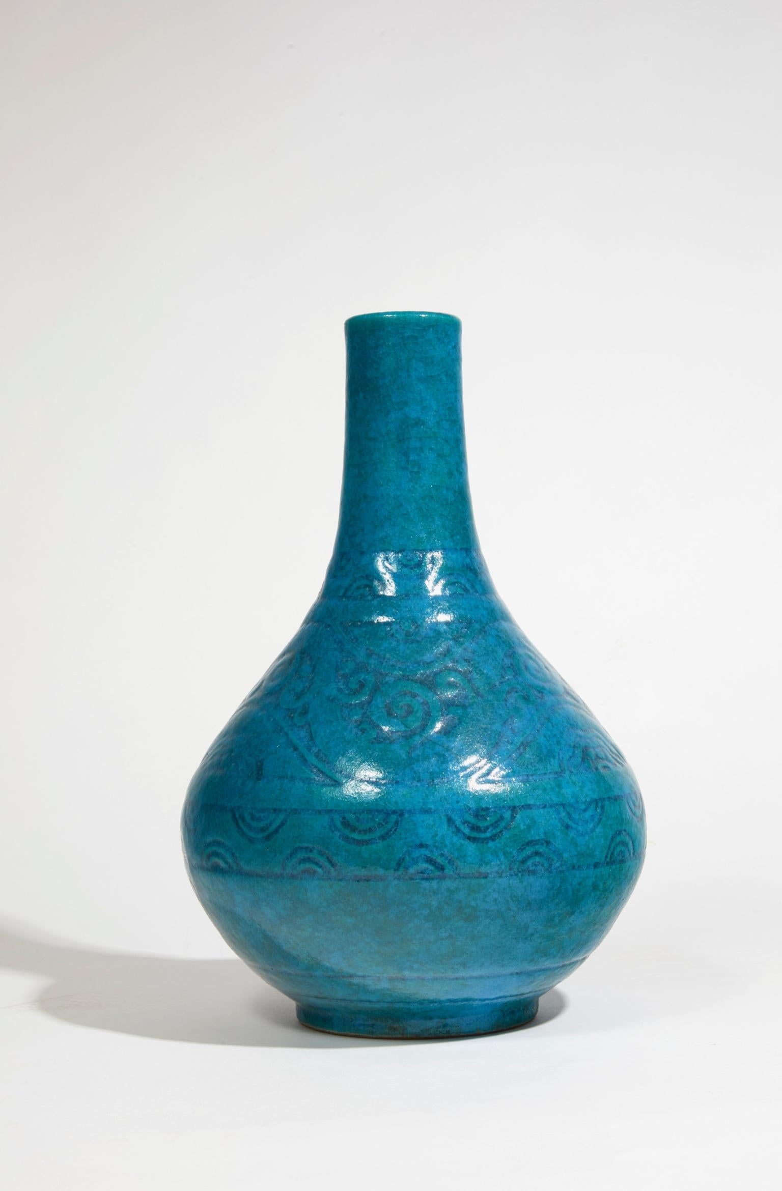 Grande vaso a balaustro in pietra con smalti blu, blu anatra e blu egiziano, con decorazione incisa di un fregio vegetale e volute incorniciate da due fregi geometrici. Firma in incavo del timbro dell'artista.