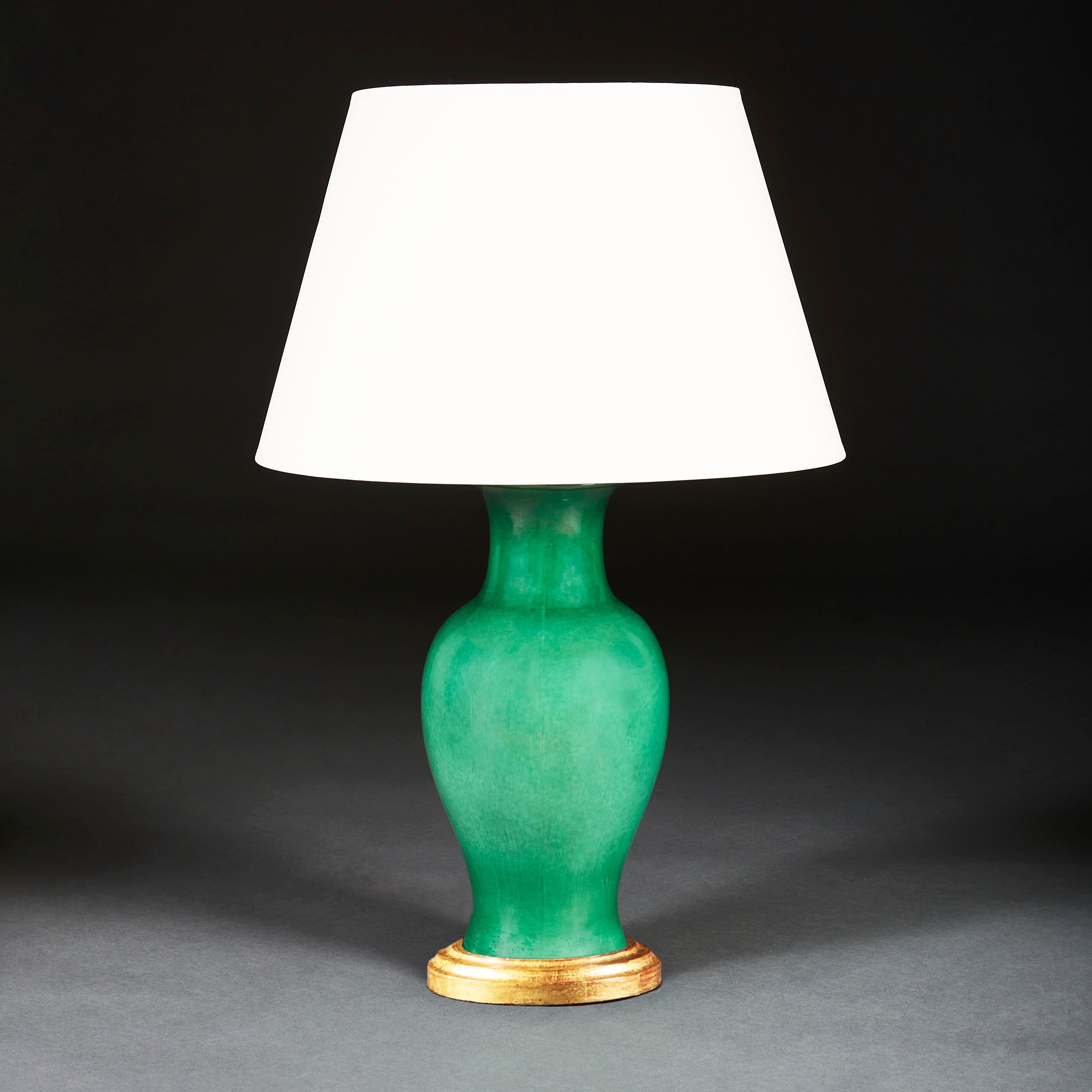 A large Chinese baluster form ceramic vase with apple green glaze, now mounted as a lamp with a turned giltwood base.

Please note: Lampshade not included.
  
Currently wired for the UK.