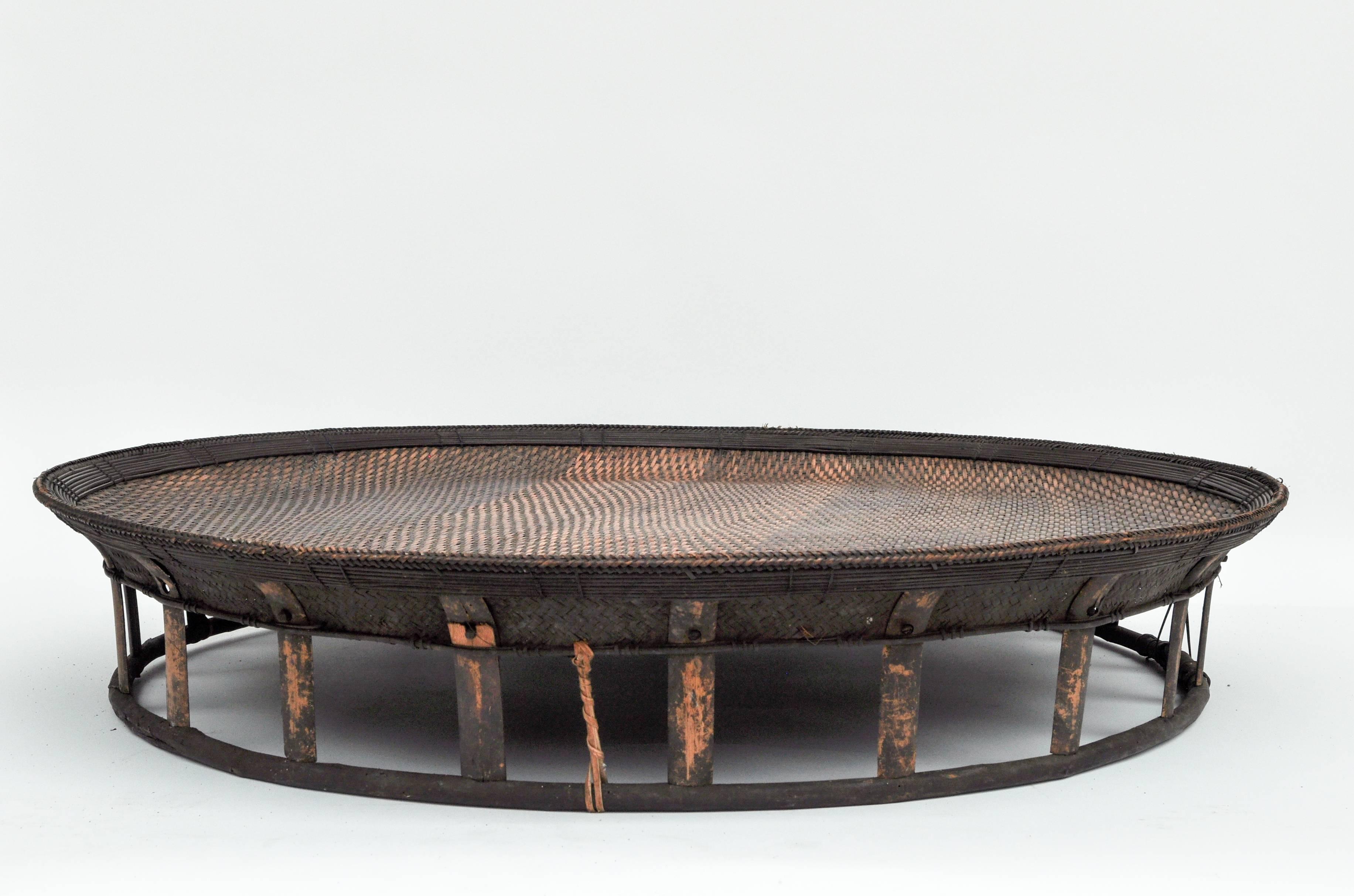 Large bamboo and rattan basket table or tray, Laos, mid-late-20th century.
Offered by Bruce Hughes.
This large rattan and bamboo piece served as a table in a Lao rural family home. 
Dimensions: 30 inches diameter by 6 inches tall.
 