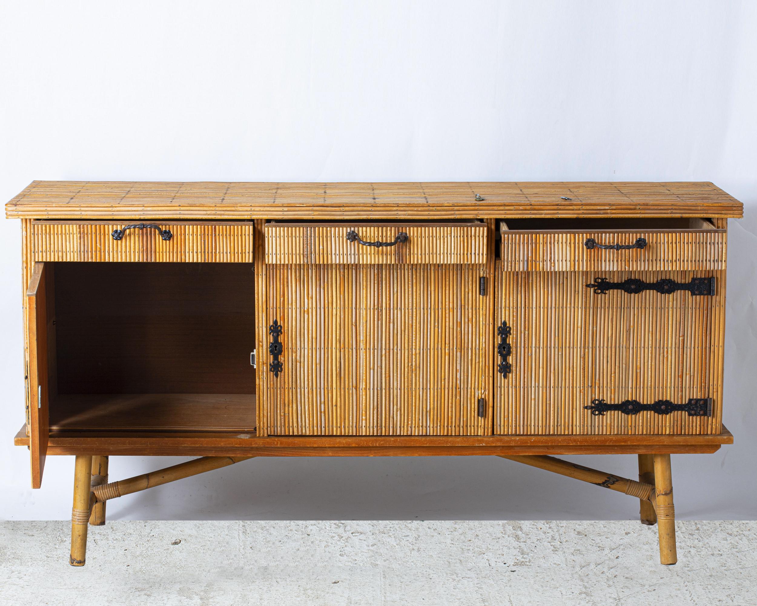 Large enfilade with three doors and three drawers in bamboo and wood entirely covered with split bamboo. In the spirit of Audoux-Minnet. France circa 1960.

Story : 

Audoux-Minnet, French House active from 1929 to 1965

Founded by Adrien Adoux &