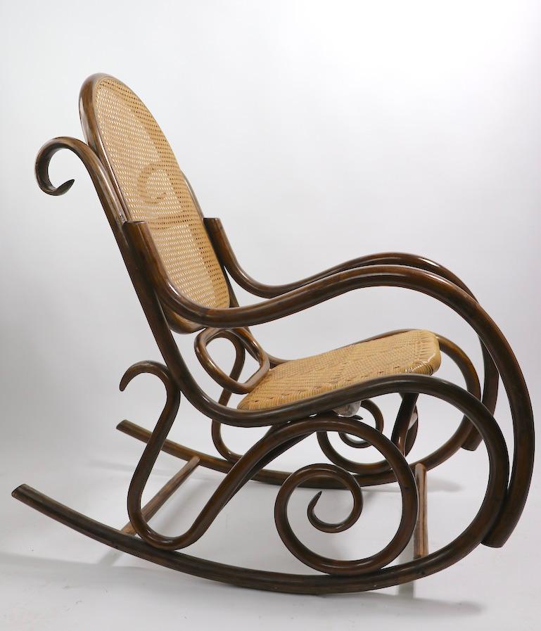 Incredible stylish over scale midcentury continuous arm rocking chair, after Thonet and Albini. Bent bamboo frame, with original cane and wicker seat and back. This example is in very fine, original condition, clean and ready to use.
 Measures: