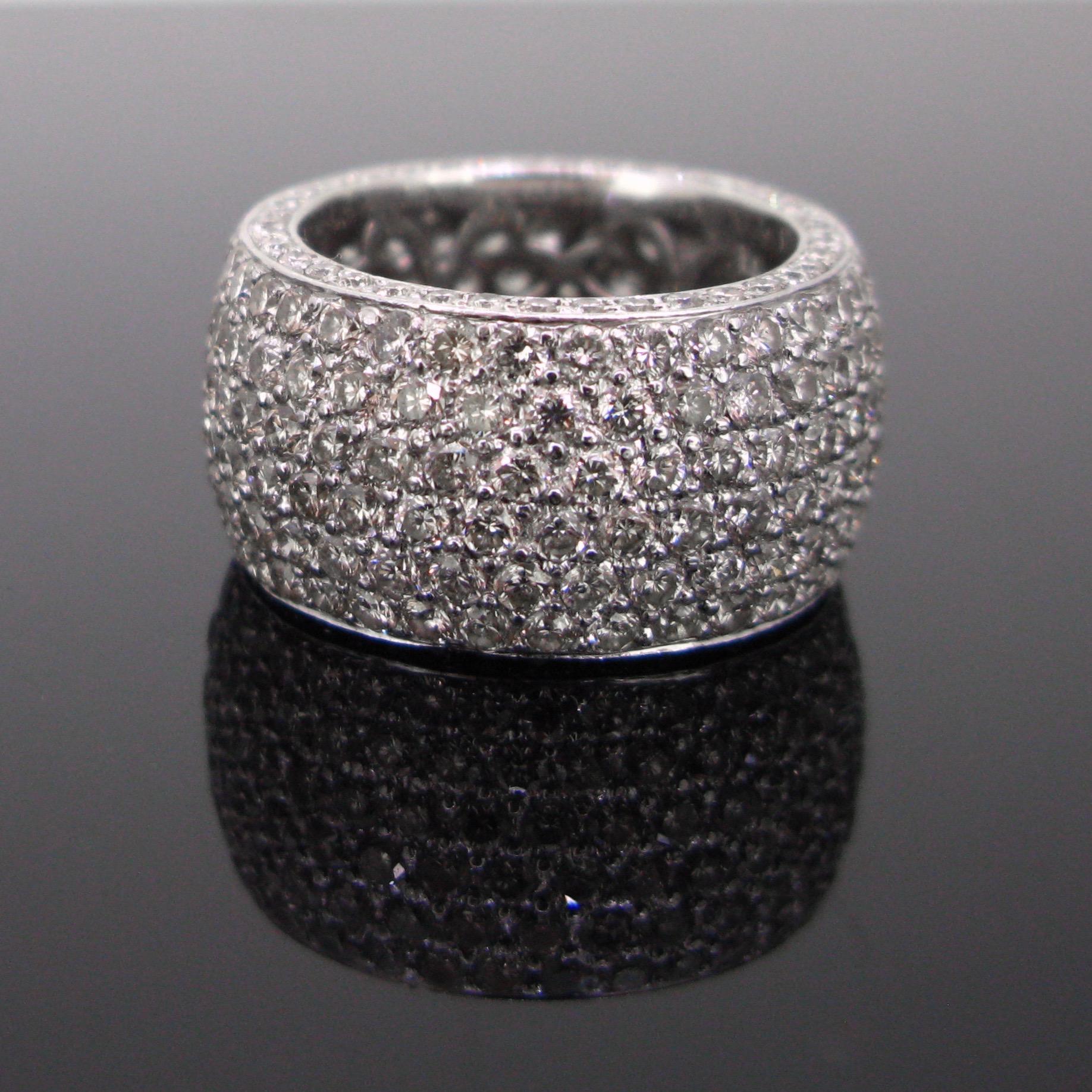 This beautiful band ring is paved with 6 lines of brilliant cut diamonds. The ring is engraved inside with D692 for the total carat weight.  There is a a total carat weight of 6.92ct. It has a nice flowery design inside. The ring was also adorned