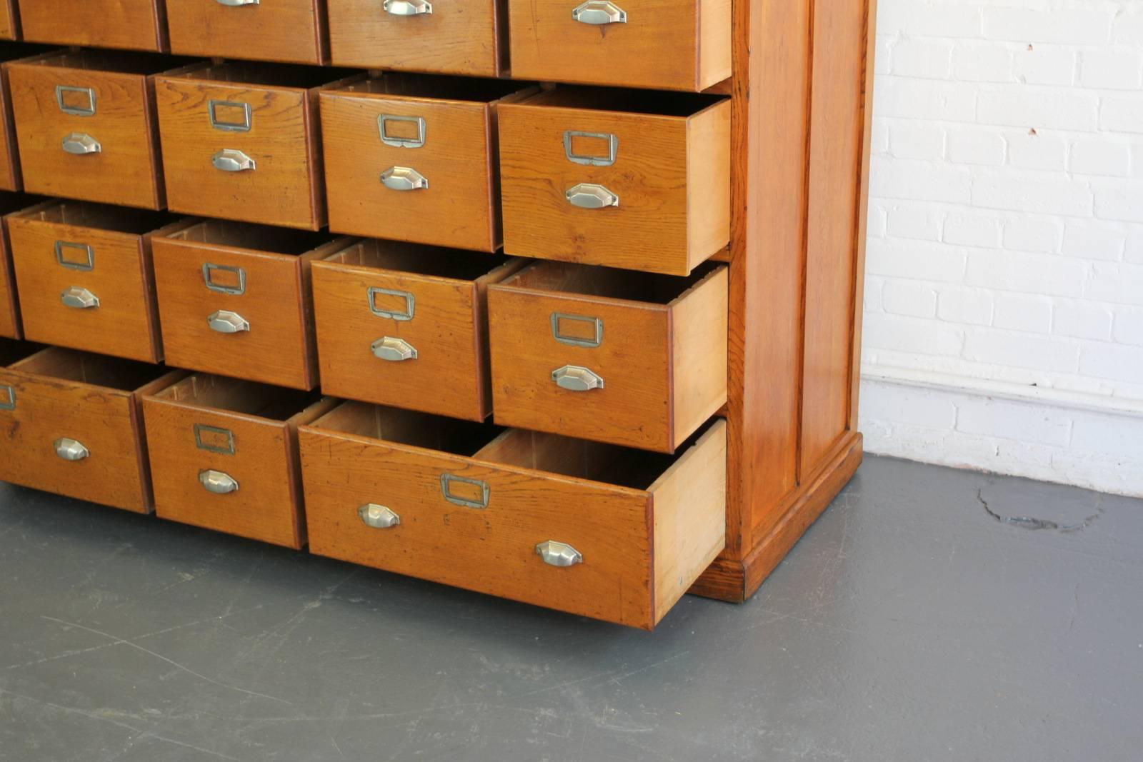 Large bank of French Art Deco filing drawers, circa 1930s

- Solid oak drawers and frame
- Oak ply panels on the sides
- Geometric cup handles
- 21 small drawers and two large
- French, circa 1930s
- Measures: 173 cm wide x 66 cm deep x 149