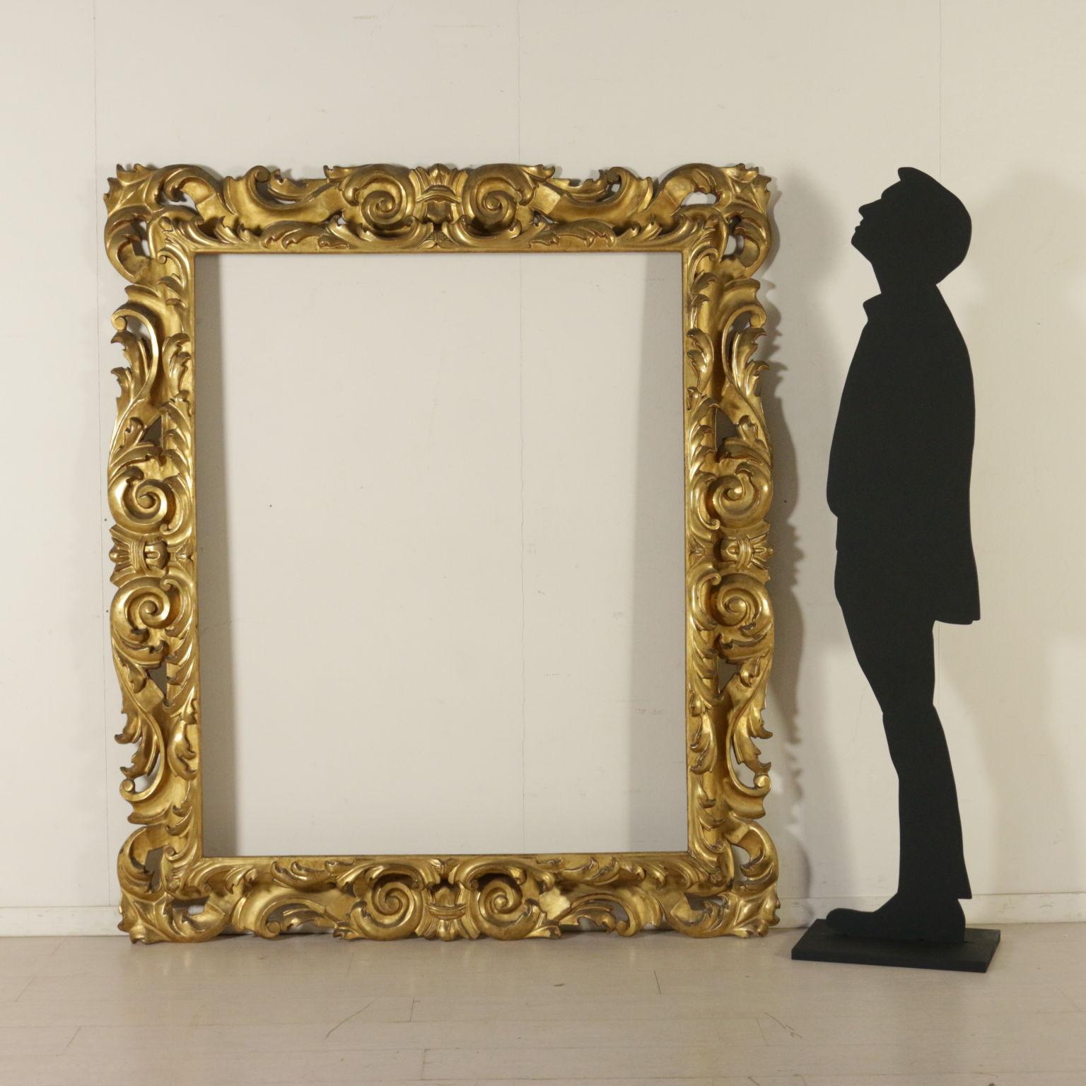 A large mirror, gilded and finely carved. Two orders of frames, volute and leaf carvings with perforations. Manufactured in Italy, 17th century.