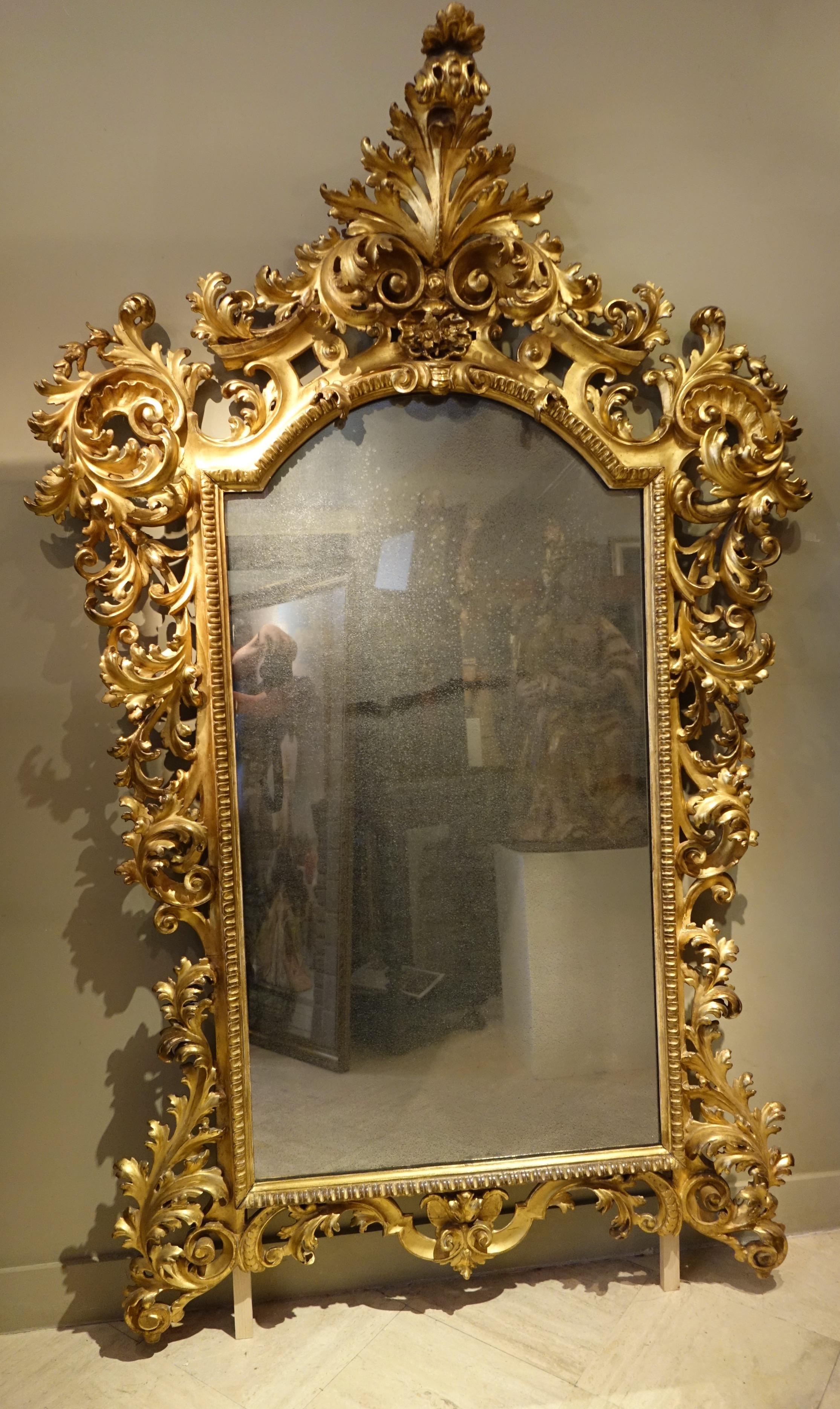 Large carved and gilded wood mirror with scrolls and foliage.
Large pediment in acanthus leaf.
Beautiful impression of lightness due to the openwork on the four sides.
Mirror with mercury, not original parquetry at the back.
Southern Italy, probably