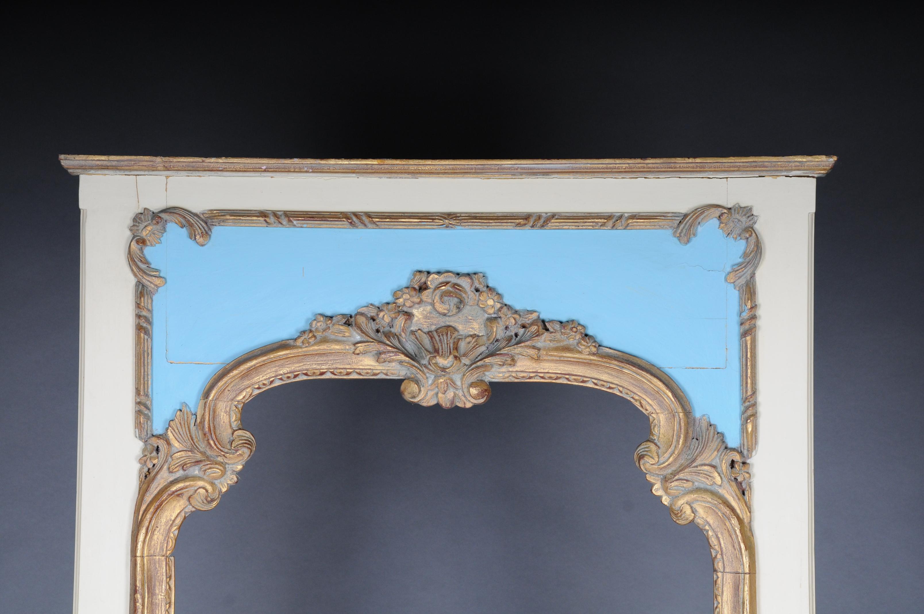 Solid wood, pastel colored and poliment gilt. Rectangular profiled mirror frame. Pediment with a plastic crown made of a medallion and plastic flowers. Centered mirror glass. Nice patina.

(M-Sai-6).