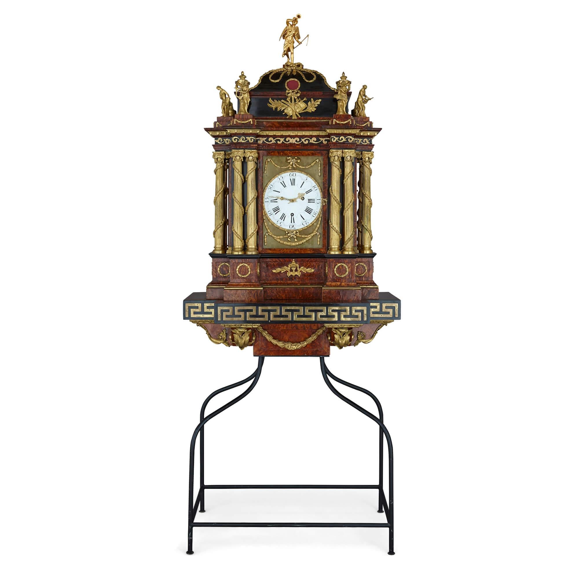 Large Baroque style Austrian ormolu mounted musical clock
Austrian, early 19th Century
Total height: 211cm
Clock: Height 135cm, width 86cm, depth 52
Stand: Height 76cm, width 81cm, depth 48cm

The clock is designed in the Baroque style and in